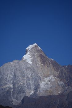 Stunning capture of Mount Machapuchare under a clear blue sky, showcasing its distinctive snowy peak.