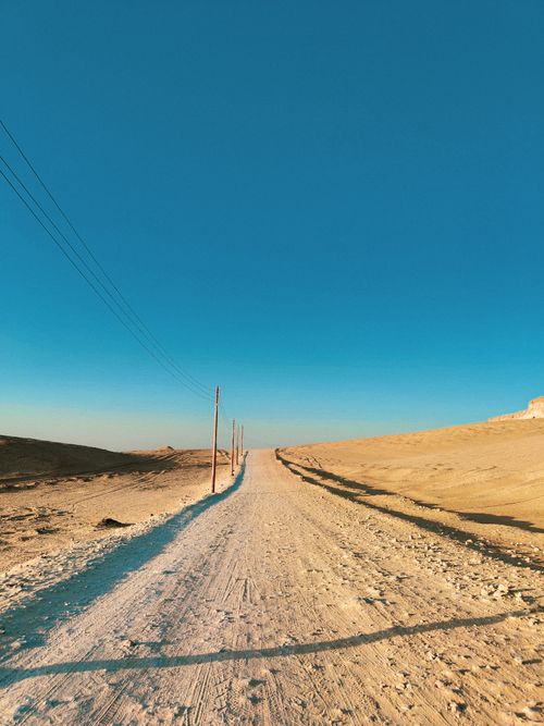 Free A wide and serene desert road in Egypt under a clear blue sky, perfect for adventure travel. Stock Photo