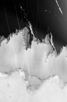 A stunning black and white abstract view resembling icy terrain with textural details.