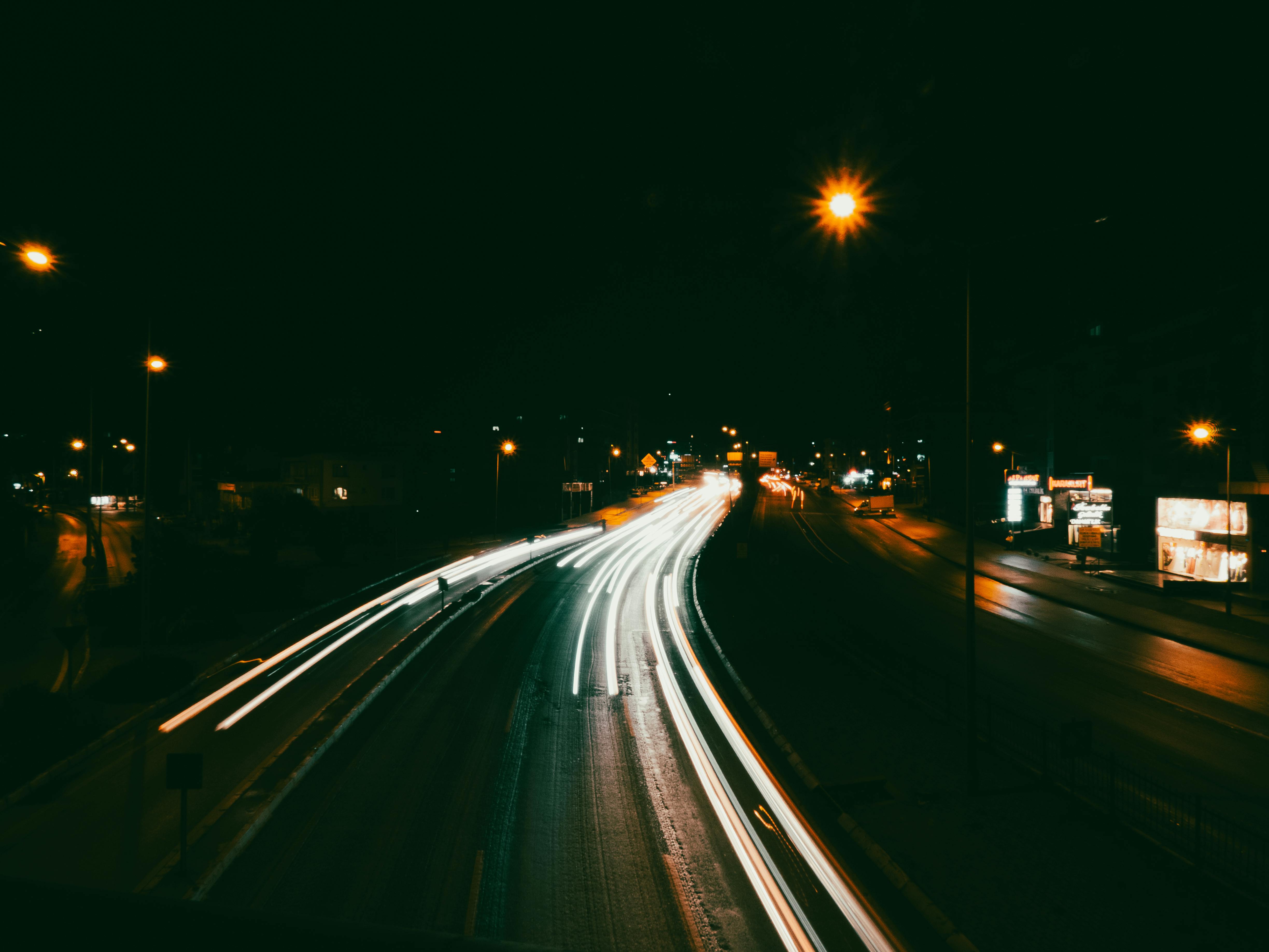 免费 长时间曝光捕捉夜间城市道路上车辆的光迹，营造出动态的运动效果。 素材图片