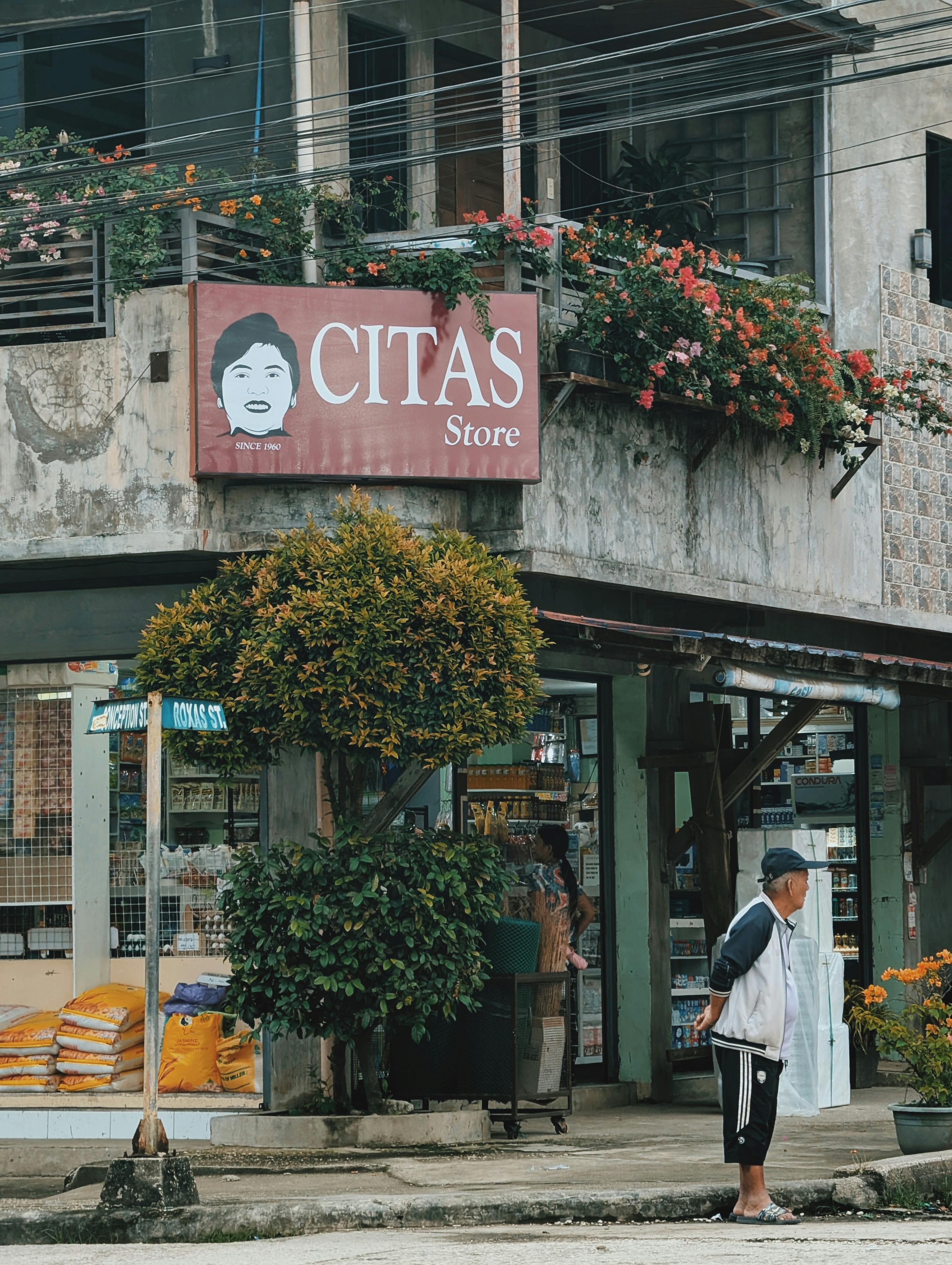 Gratis En detaljert gatevisning av CITAS-butikken i Baganga, med lokal arkitektur og livlig flora. Arkivbilde