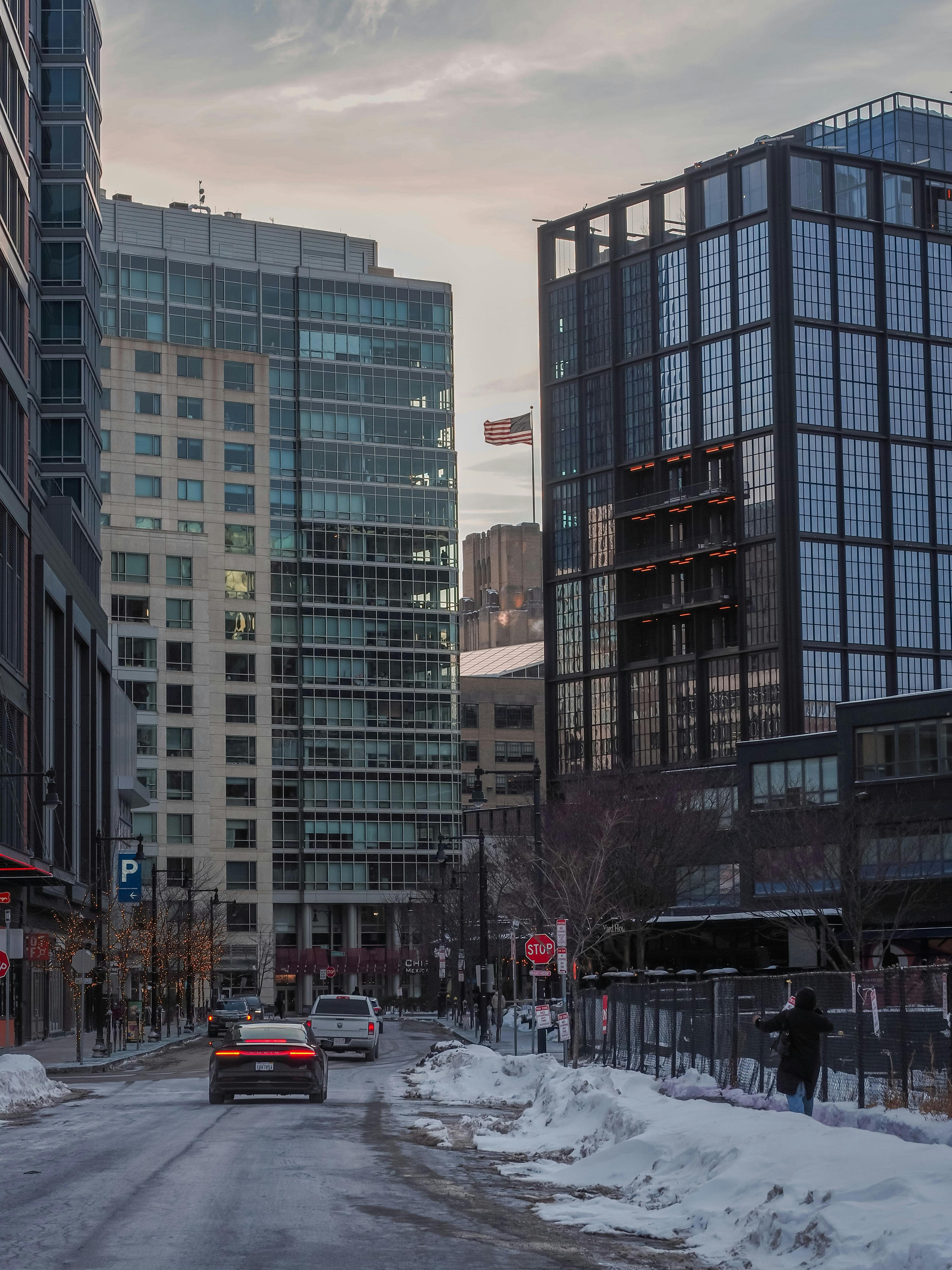 Gratis Pemandangan jalanan musim dingin perkotaan di Boston dengan gedung pencakar langit modern dan mobil-mobil yang terparkir. Foto Stok