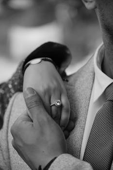 A close-up of a couple's hands showcasing an engagement ring in a romantic moment.