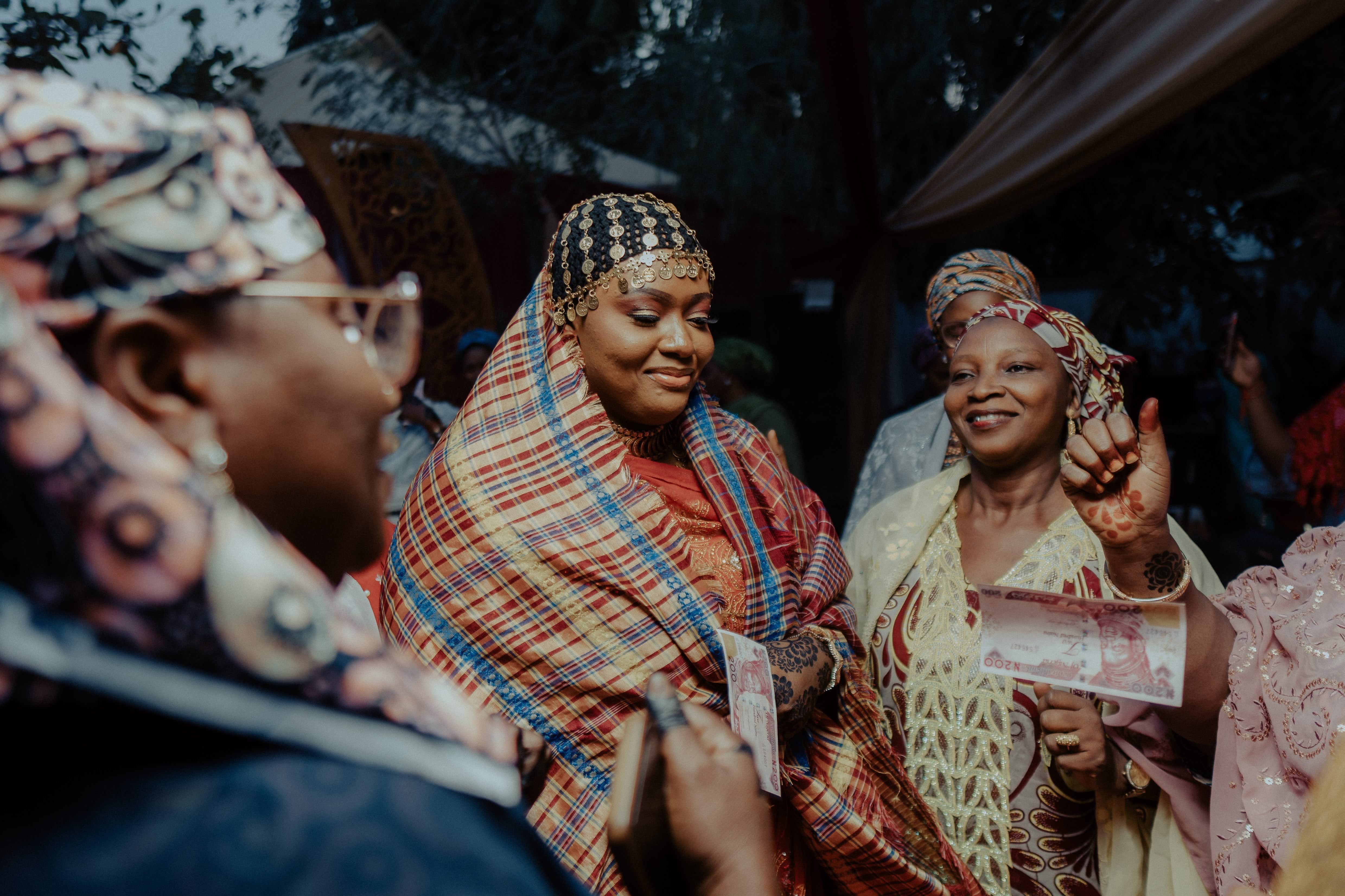 Group of women in vibrant traditional attire enjoying a cultural celebration outdoors.
