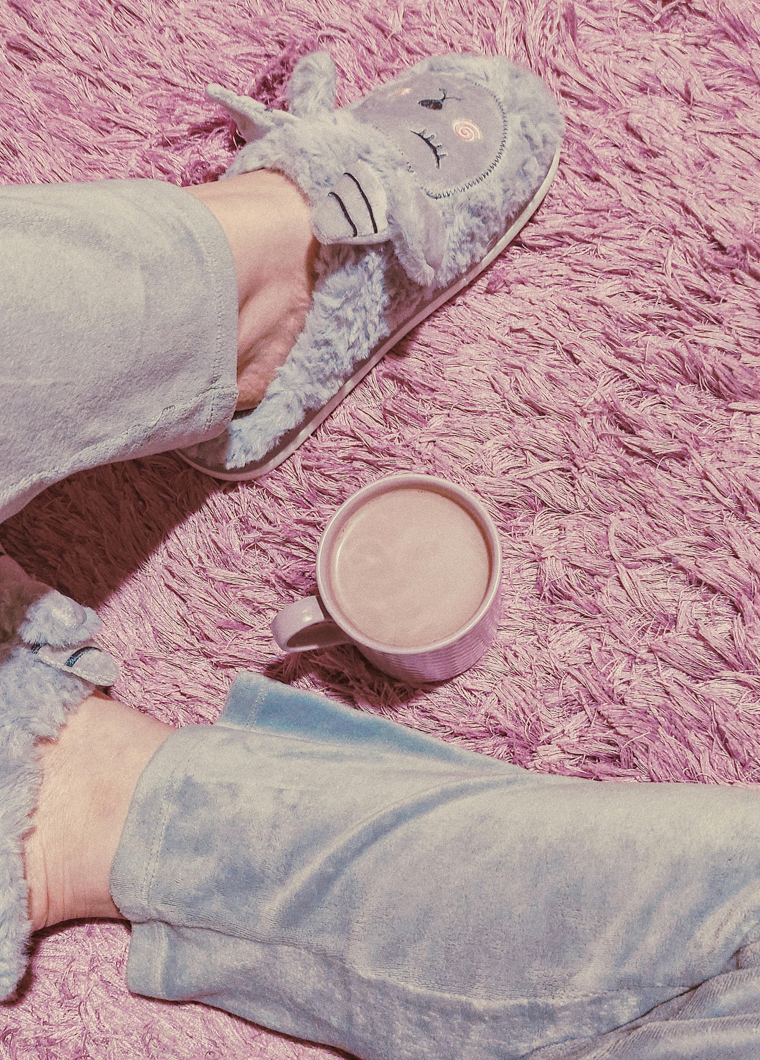 ingyenes Pasztell témájú, hangulatos reggel bolyhos papuccsal és egy bögre kávéval egy rózsaszín szőnyegen. Stockfotó