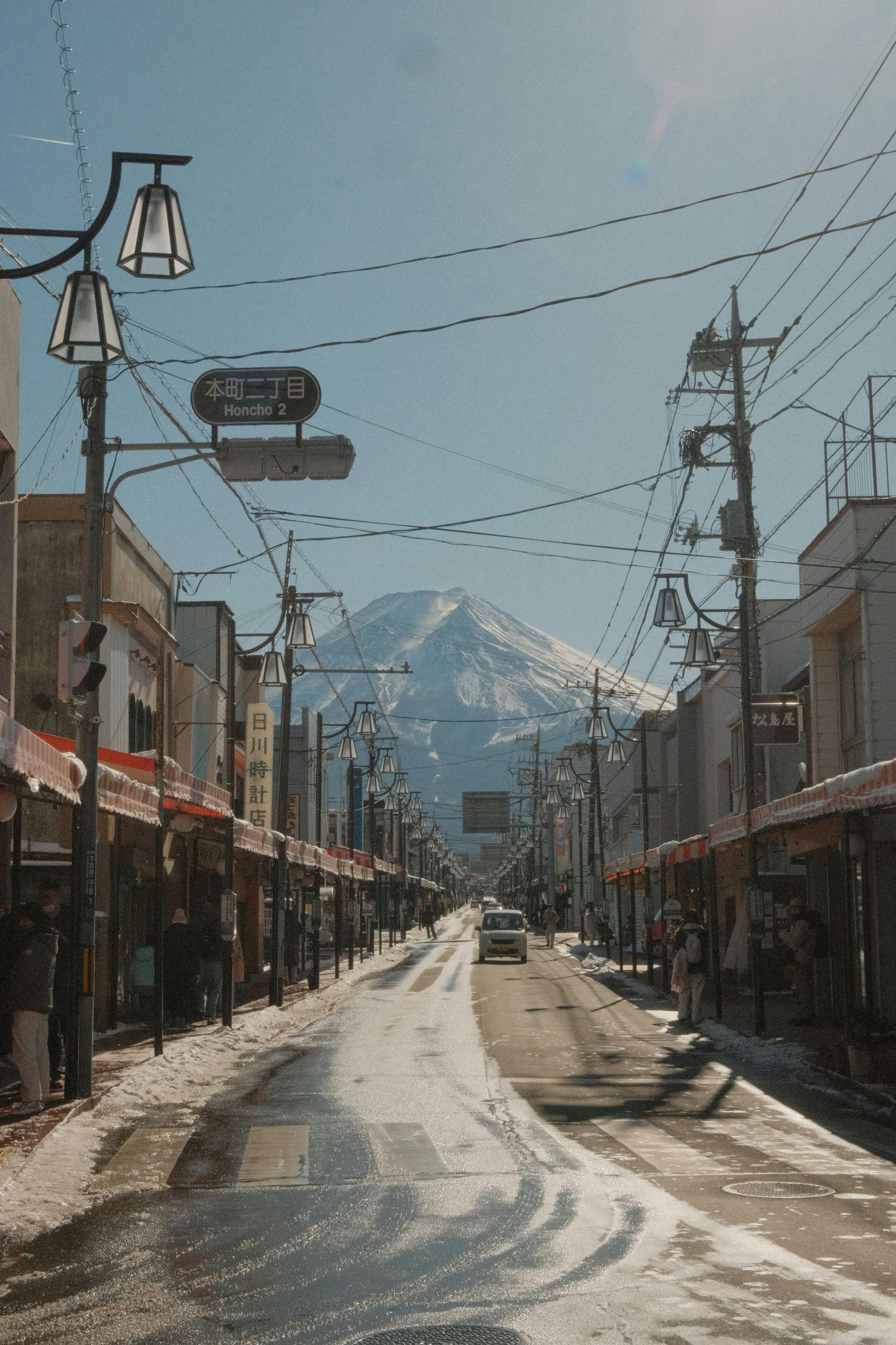Quaint Japanese street with Mount Fuji in the background during winter.