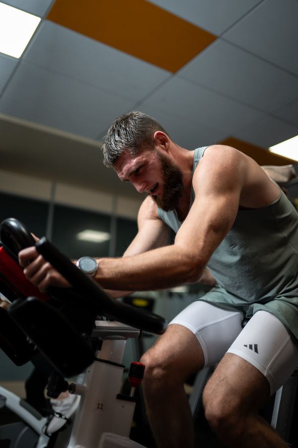 Homem pedalando na spinning bike