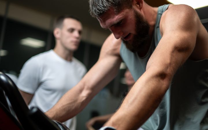 Focused men engaged in a high-intensity indoor cycling session at the gym.