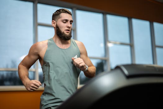 Fit young man exercising on a treadmill indoors, focused and determined.