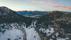 无人机在冬季捕捉到一条蜿蜒穿过雪山的道路