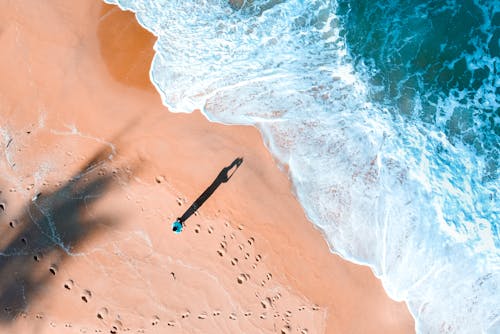 Top View Photo of Person Standing on Beach