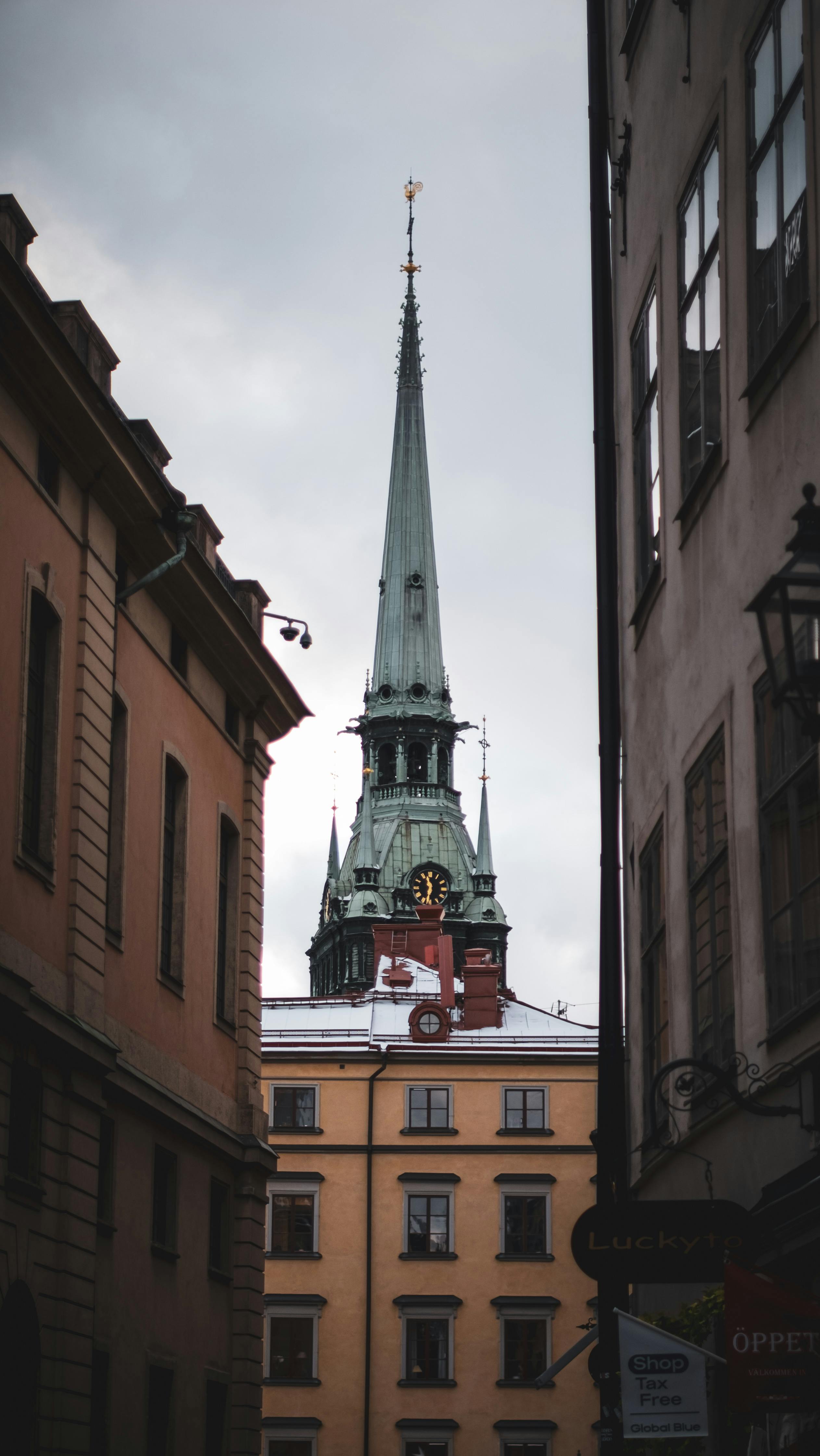 Ilmainen Lumoava näkymä tornikirkkoon Tukholman historiallisessa keskustassa, jota reunustaa klassinen eurooppalainen arkkitehtuuri. Kuvapankkikuva