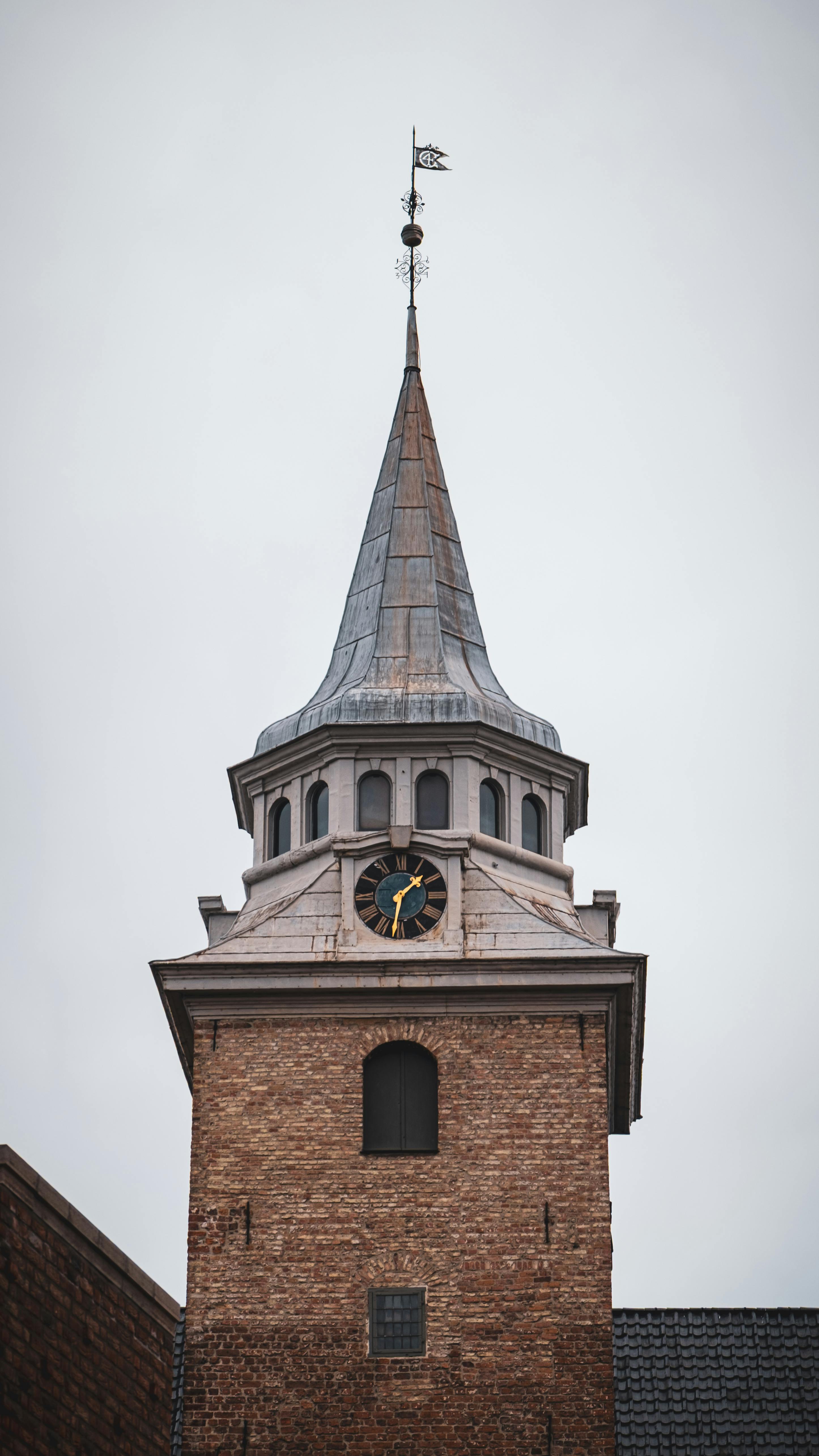 Gratis Et høyt, historisk kirketårn i Sverige med en klokkeskive under en overskyet himmel. Arkivbilde