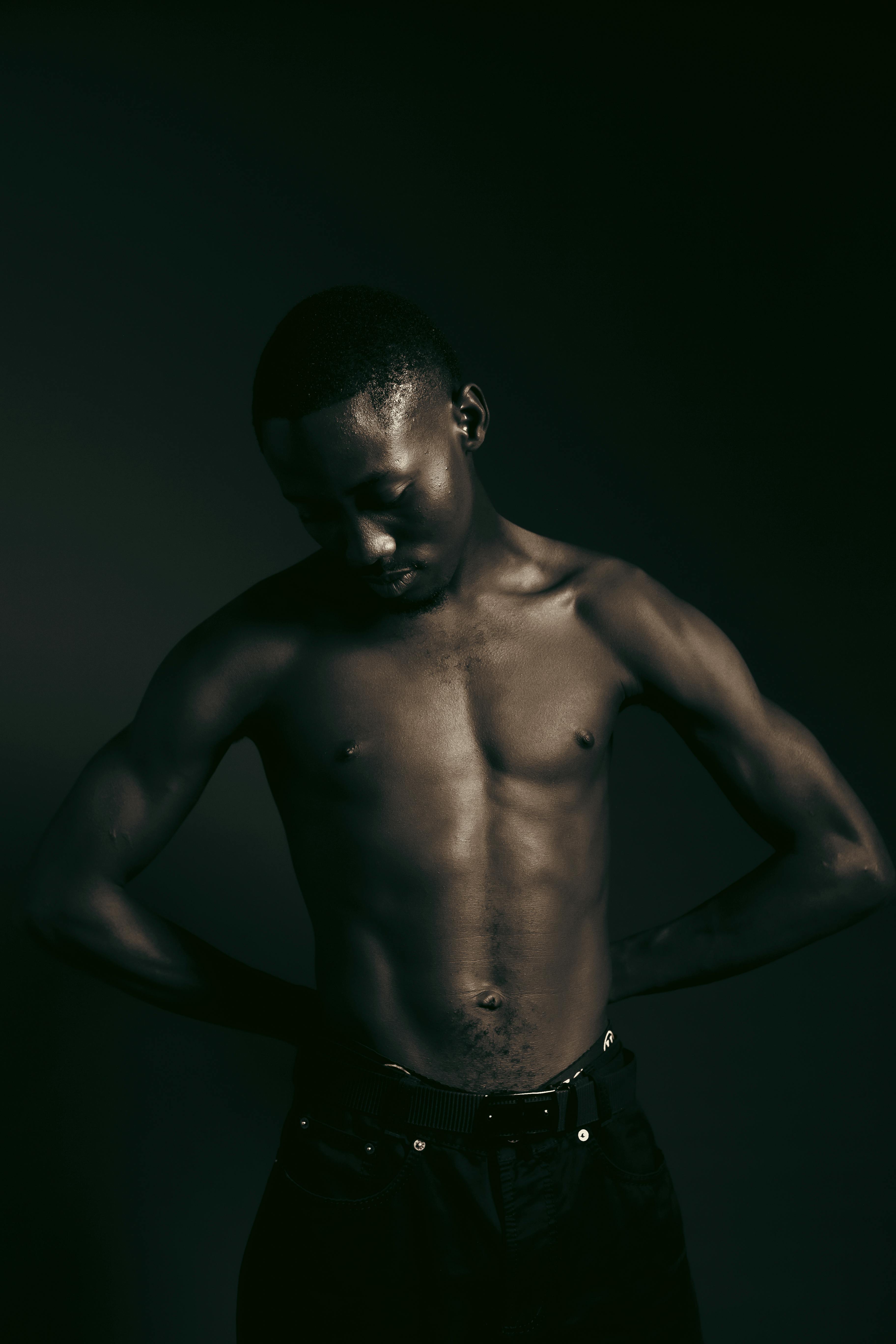 Free Artistic portrait of a young man with athletic physique in moody lighting. Stock Photo