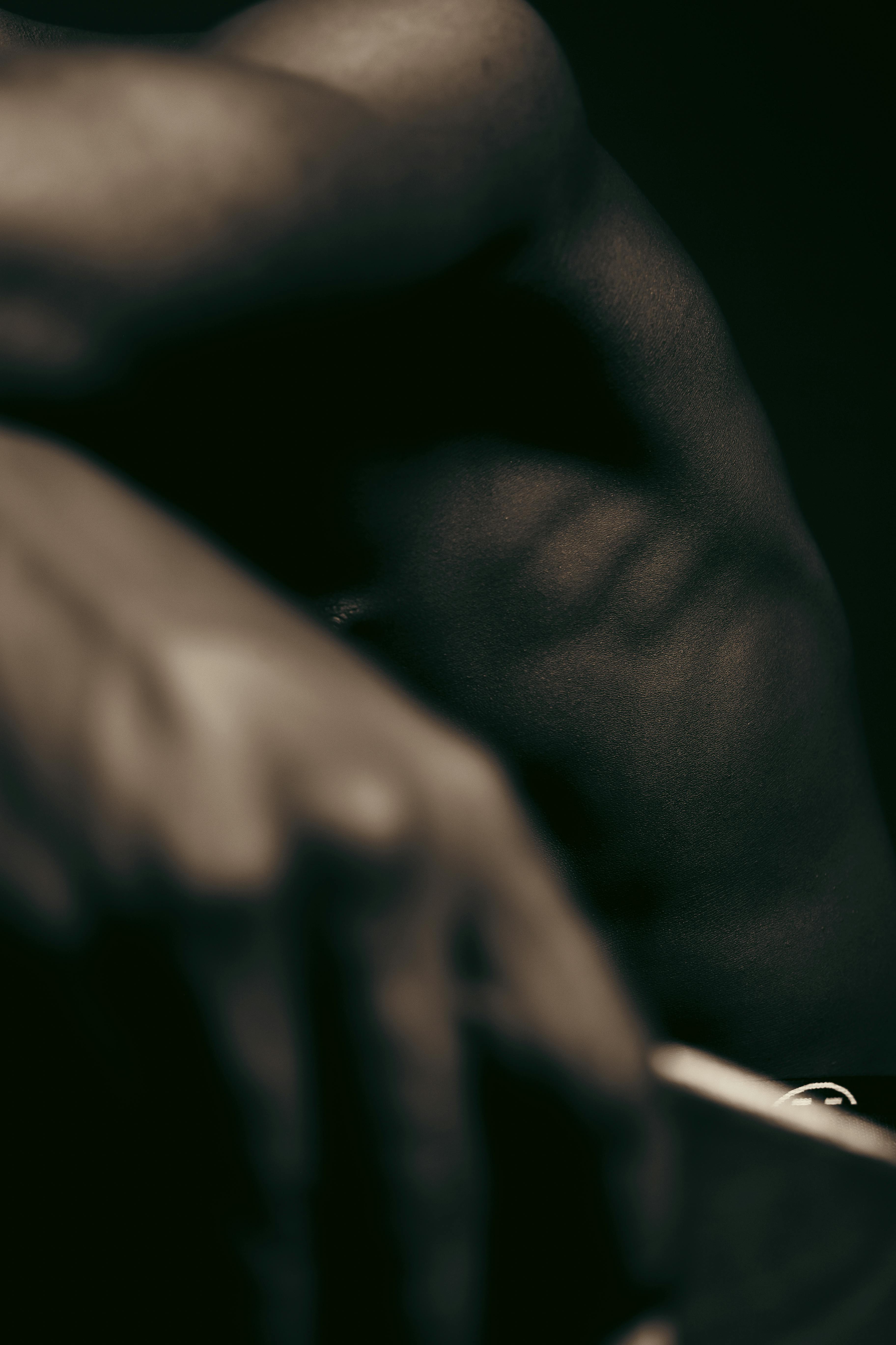 Free Artistic close-up of a muscular arm with a moody, dramatic tone. Stock Photo
