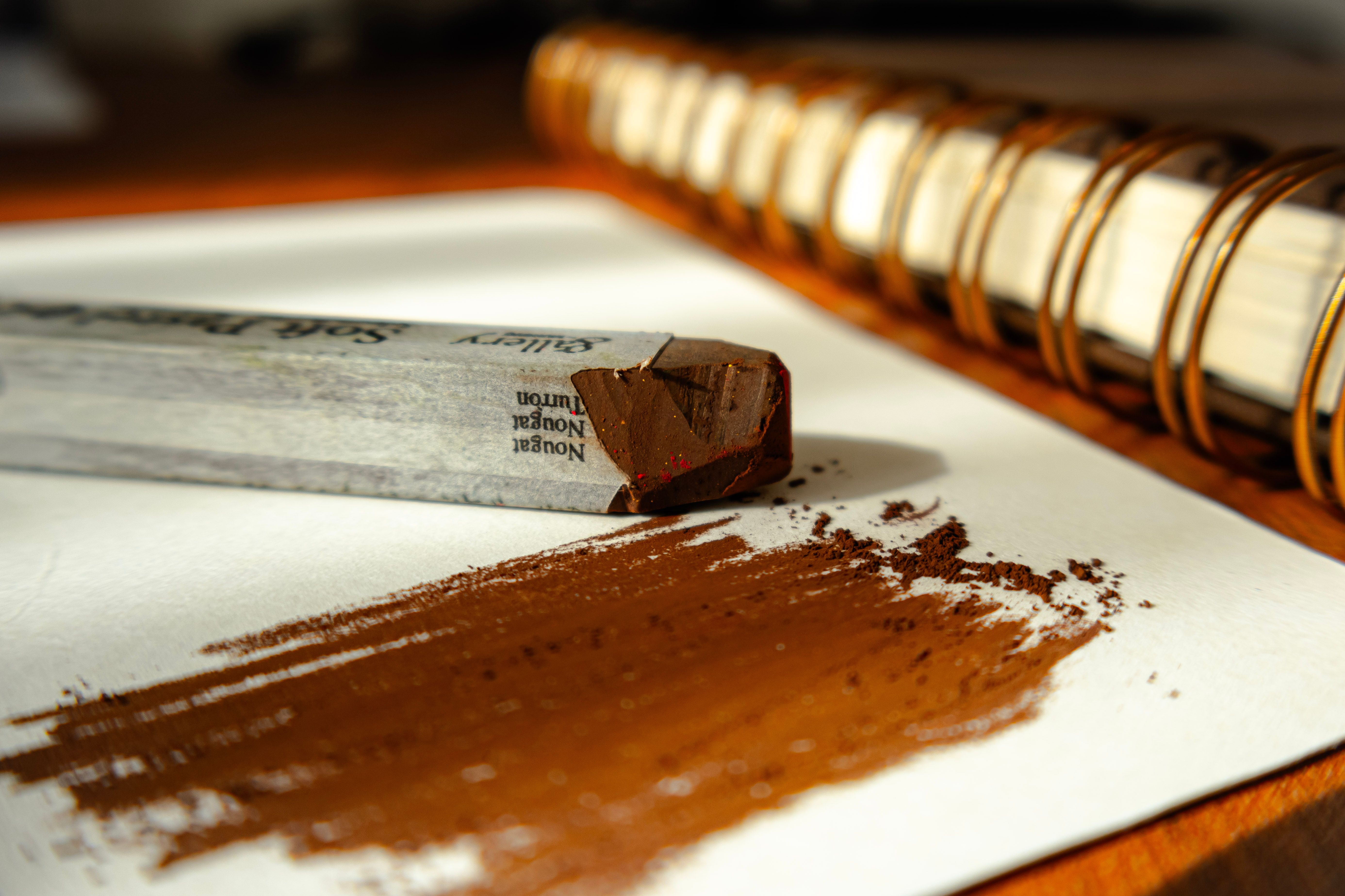 Close-up image of sketching charcoal on paper, highlighting artistic creation.