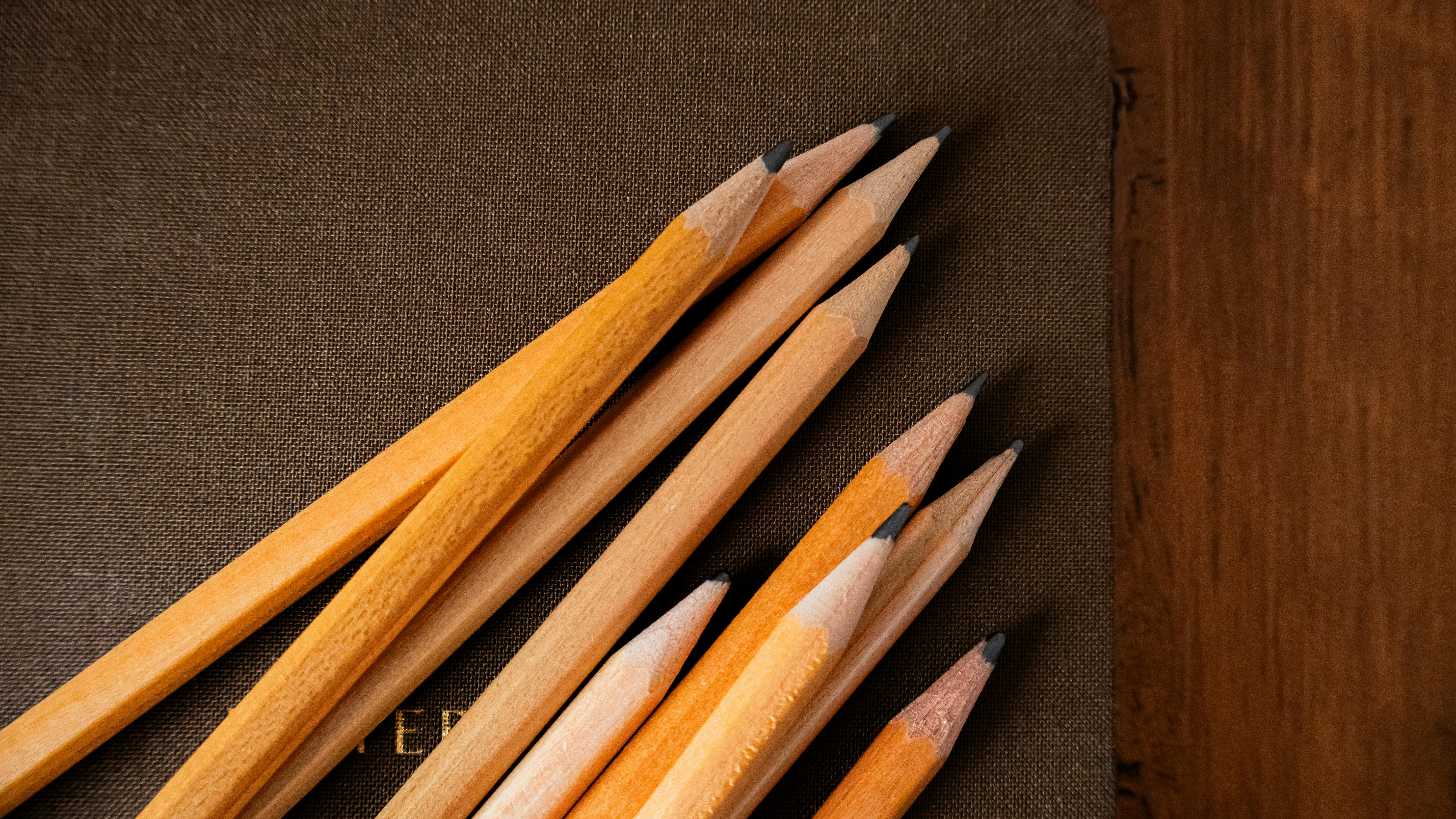 бесплатная Заточенные карандаши лежат на фактурной обложке блокнота. Фотография сделана в Стамбуле. Стоковое фото