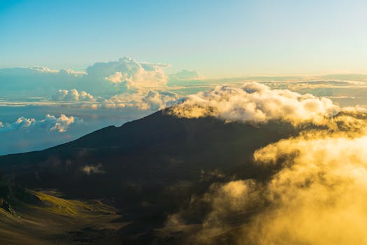 Stunning aerial view of Haleakala Volcano at sunrise with clouds enveloping the crater.
