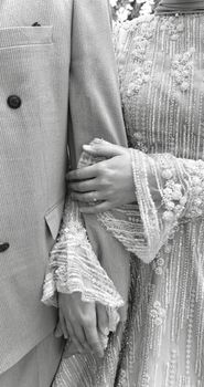 Close-up of a stylish couple holding hands in wedding attire in Bursa, Türkiye.