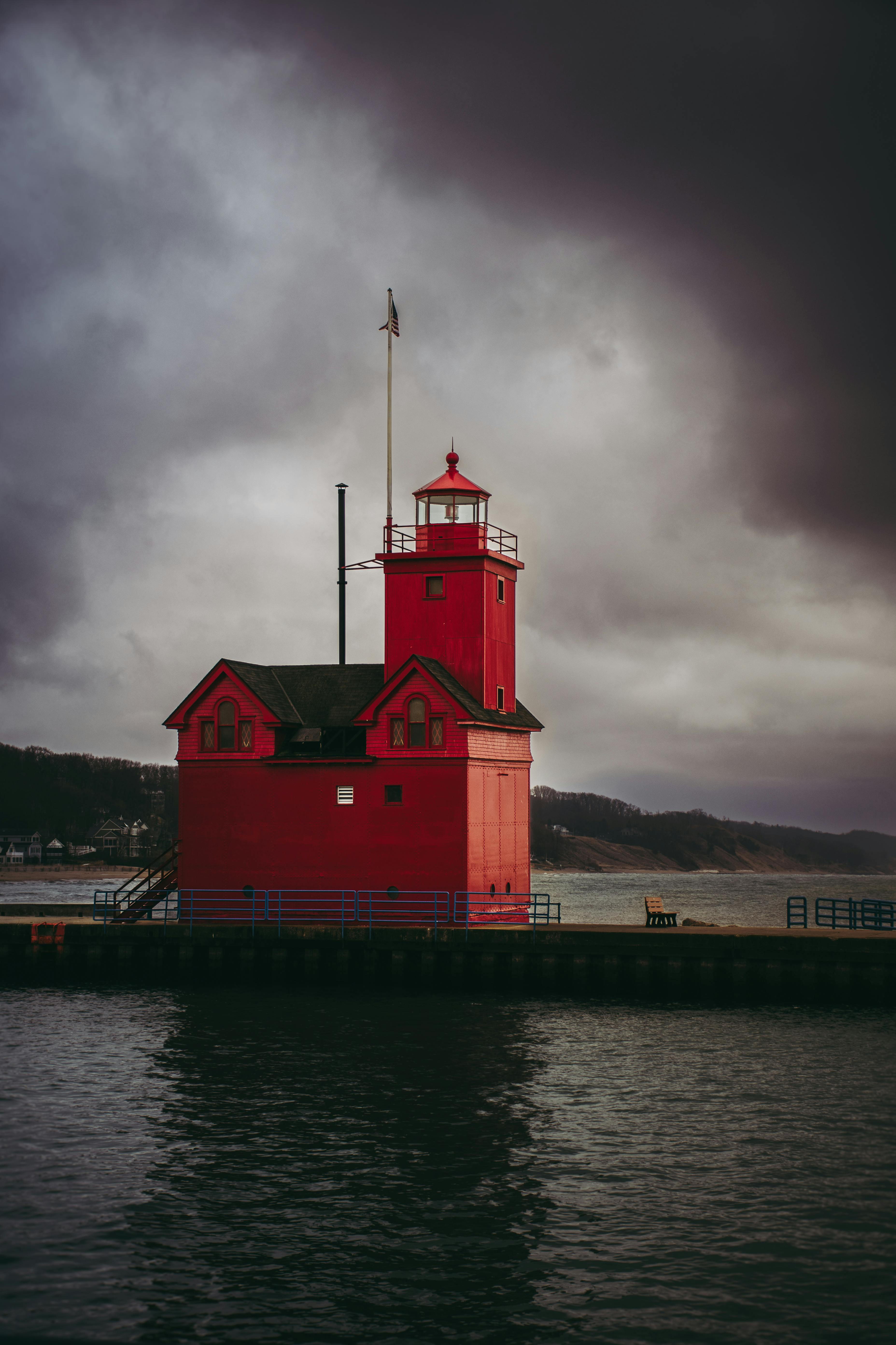 Gratis Nydelig fotografi av det røde Holland Harbor-fyrtårnet under en stemningsfull himmel ved Michigansjøen. Arkivbilde