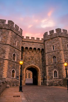 Enchanting view of Windsor Castle's entrance as twilight sets in, highlighting its historic architecture.