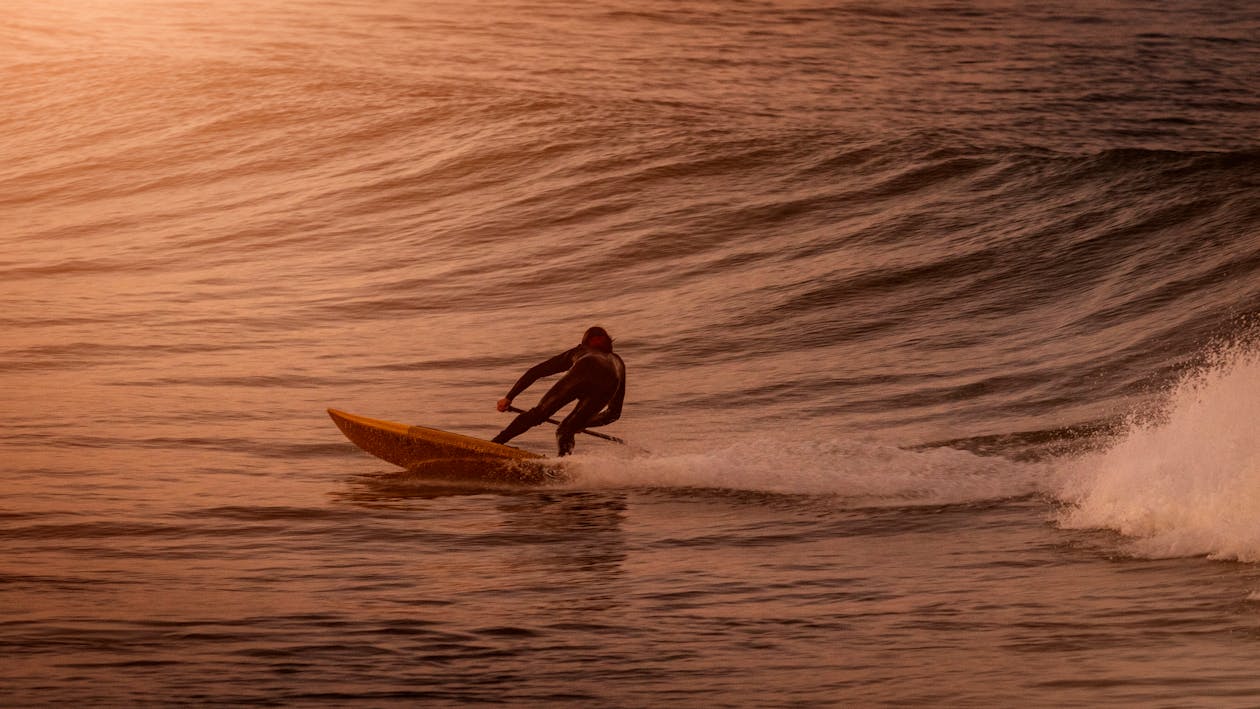 Homem De Terno Preto Surfando No Mar