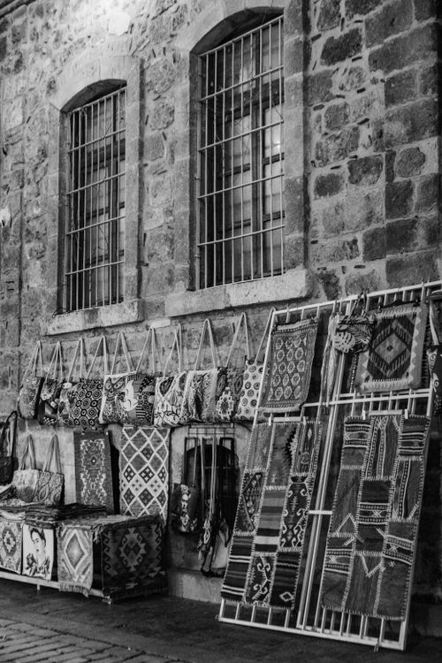 Free A captivating display of traditional handmade textiles against a stone wall, capturing cultural craftsmanship. Stock Photo