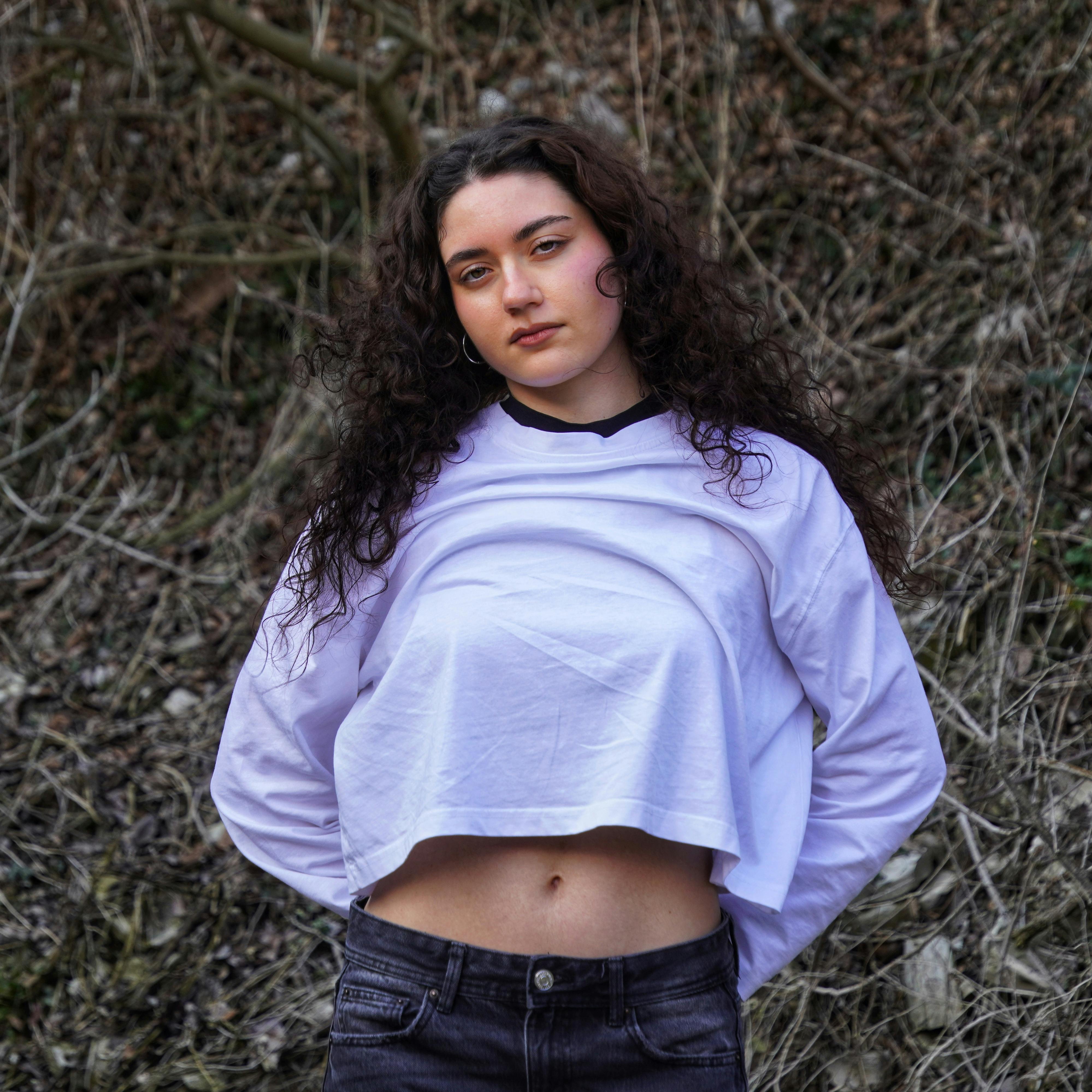 Miễn phí Chân dung một phụ nữ trẻ trong trang phục thường ngày đứng giữa thiên nhiên. Ảnh lưu trữ