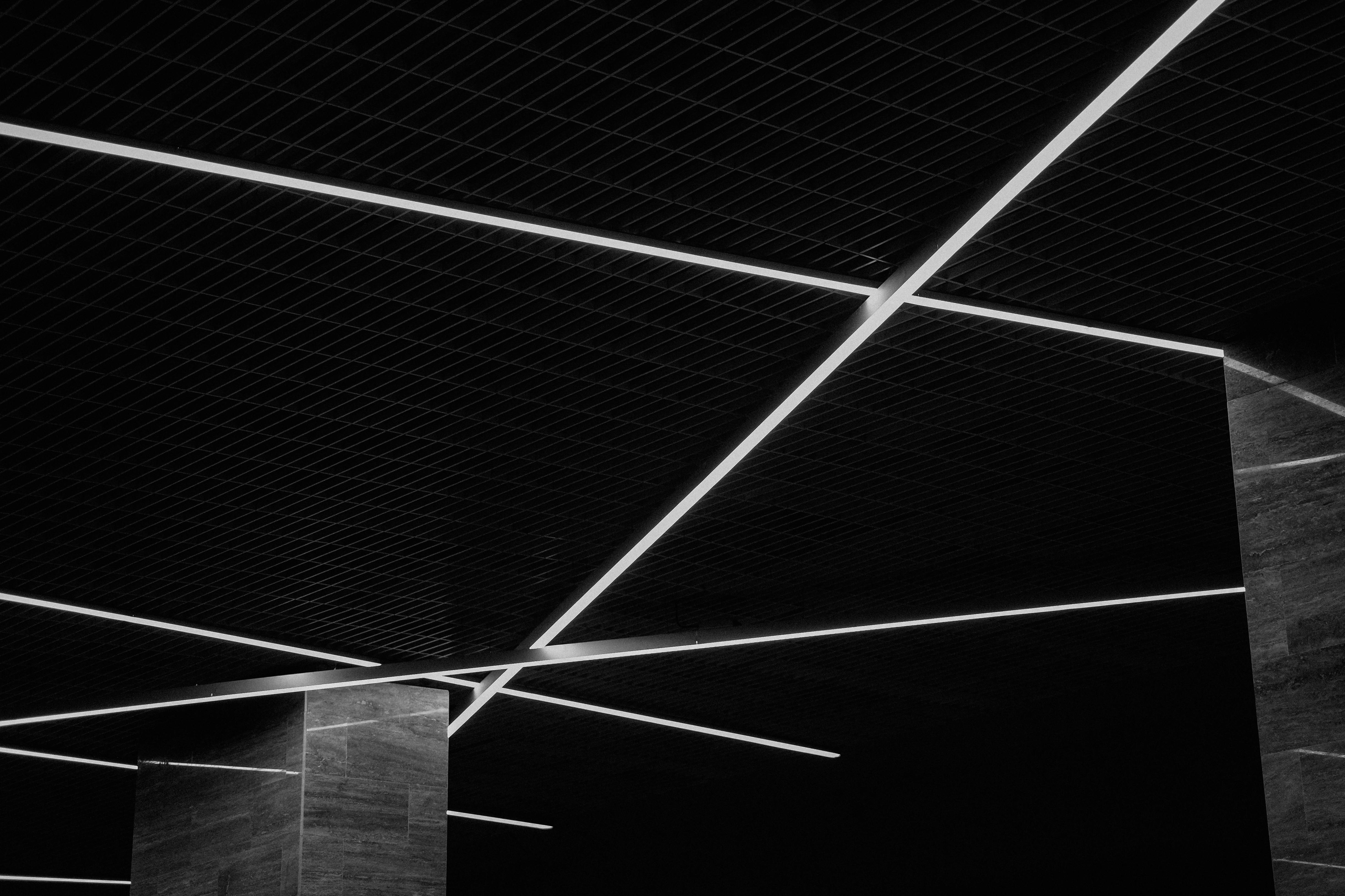 gratis Abstracte zwart-witweergave van een modern plafond met geometrische lichtpatronen en texturen. Stockfoto