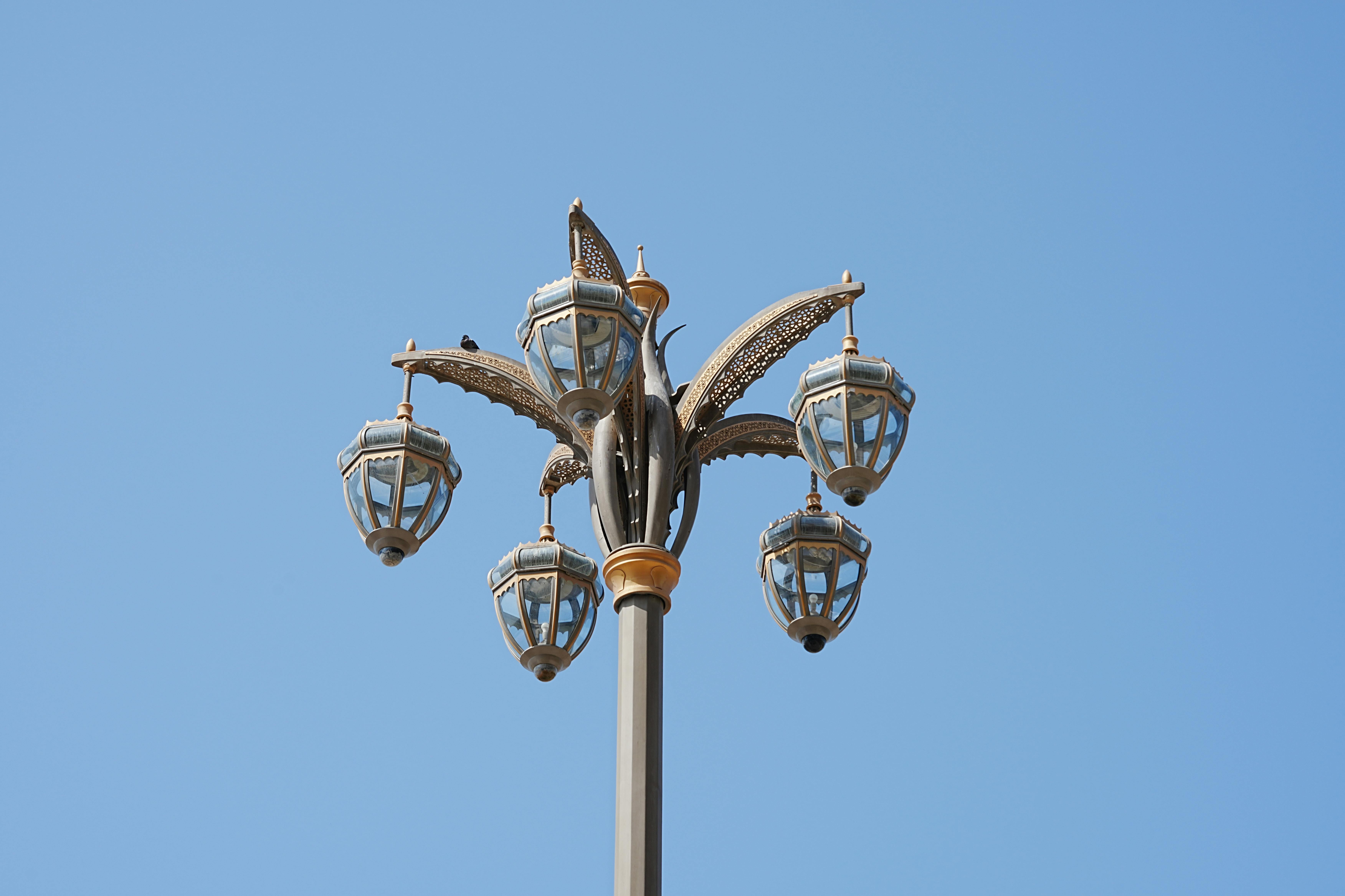 Free Elegant Dubai street lamp with intricate design set against a clear blue sky. Urban architectural detail. Stock Photo