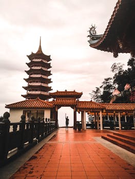 Stunning view of Chin Swee Caves Temple's pagoda during sunset with a lone figure standing underneath.