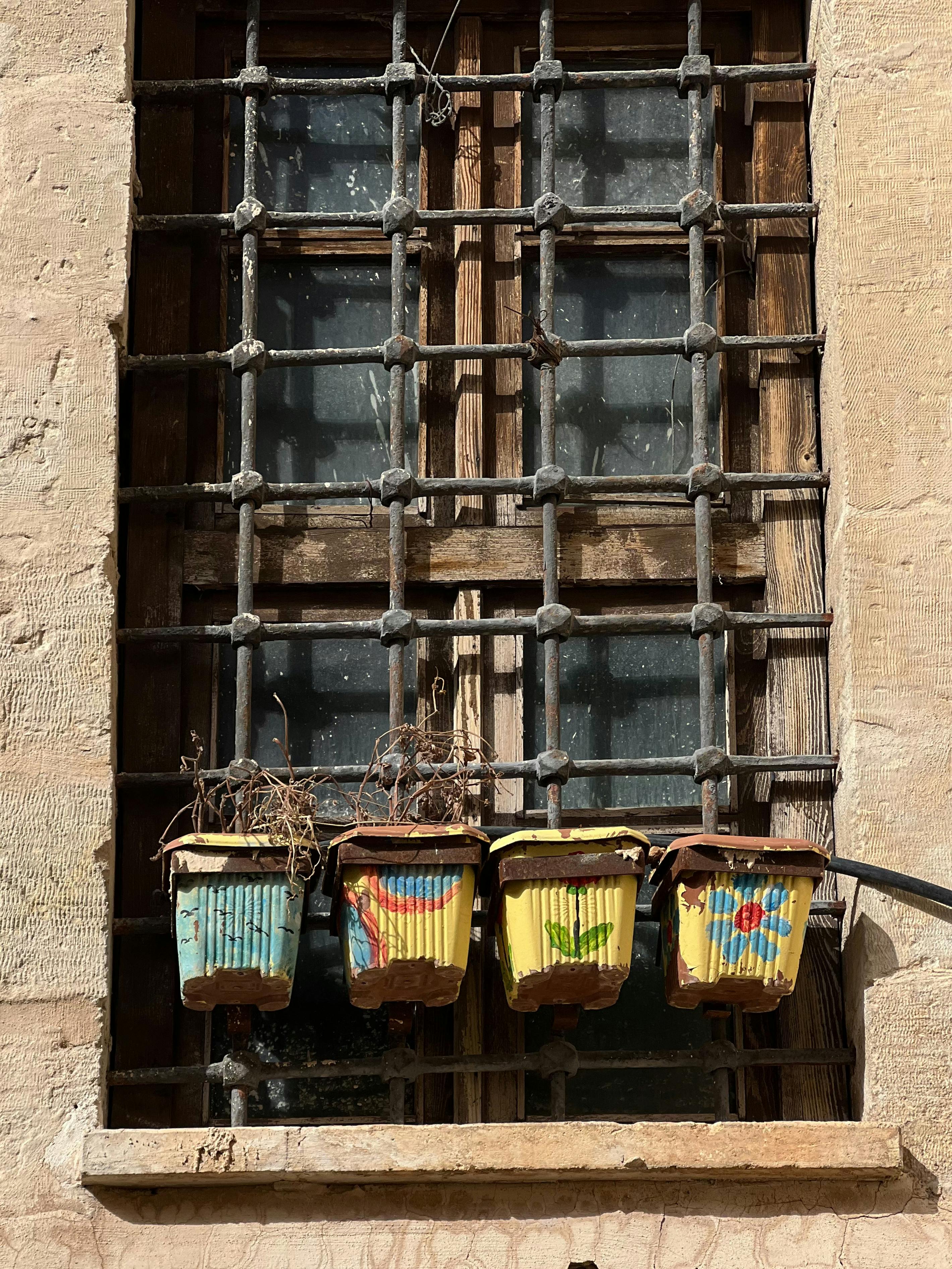 Ilmainen Maalaismainen ikkuna ja värikkäät riippuruukut esittelevät urbaania ulkoilman charmia. Kuvapankkikuva