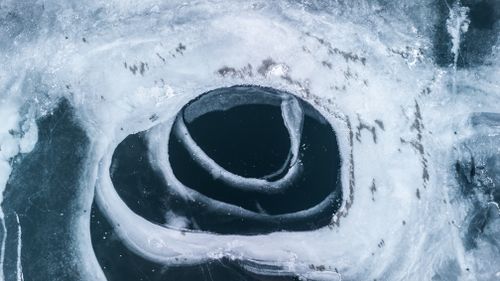 Free Top-down view of unique ice formations on a frozen lake captured in winter. Stock Photo