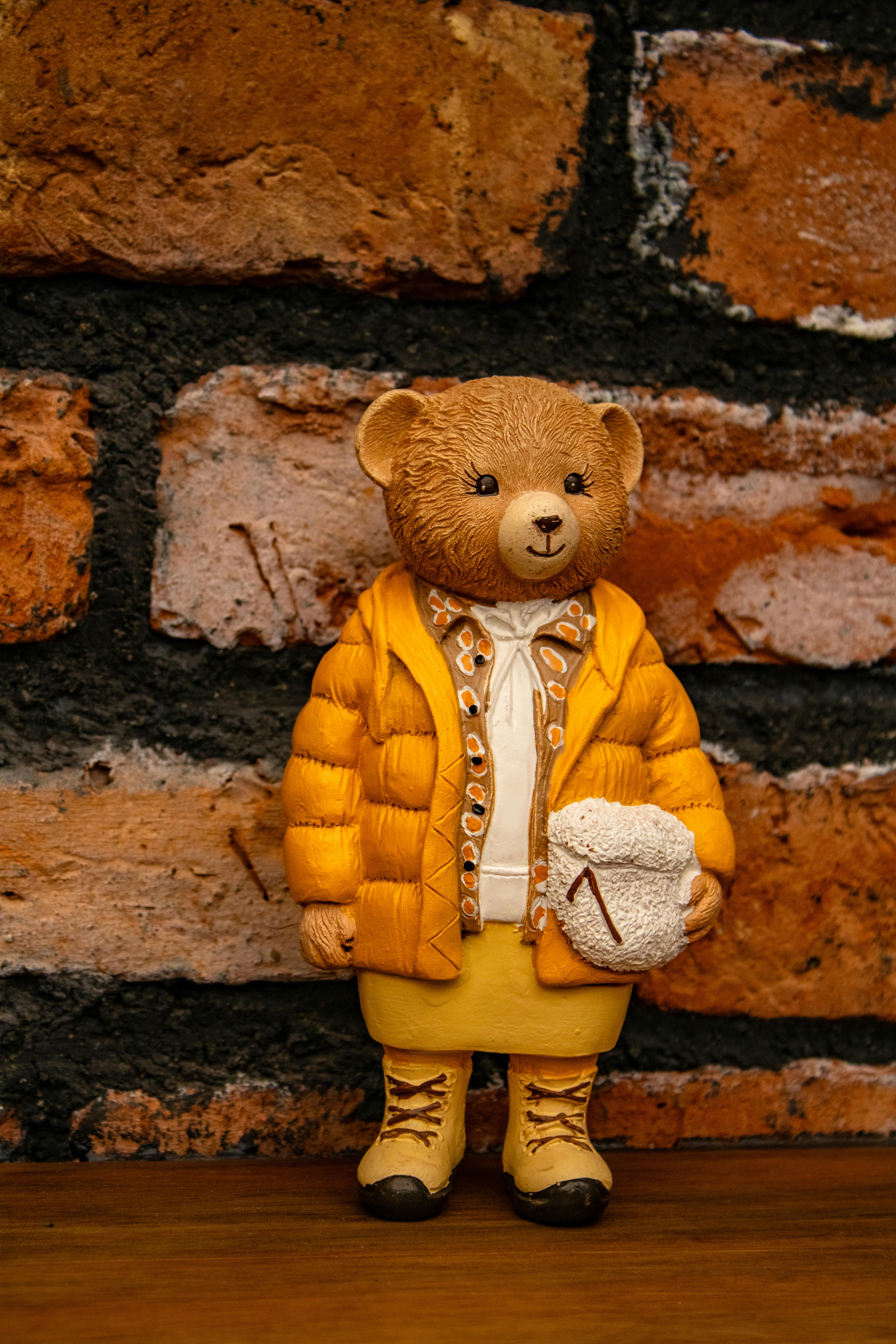 Δωρεάν Αξιολάτρευτο αρκουδάκι με ζεστή χειμωνιάτικη στολή, τοποθετημένο σε ρουστίκ τοίχο από τούβλα. Φωτογραφία από στοκ φωτογραφιών