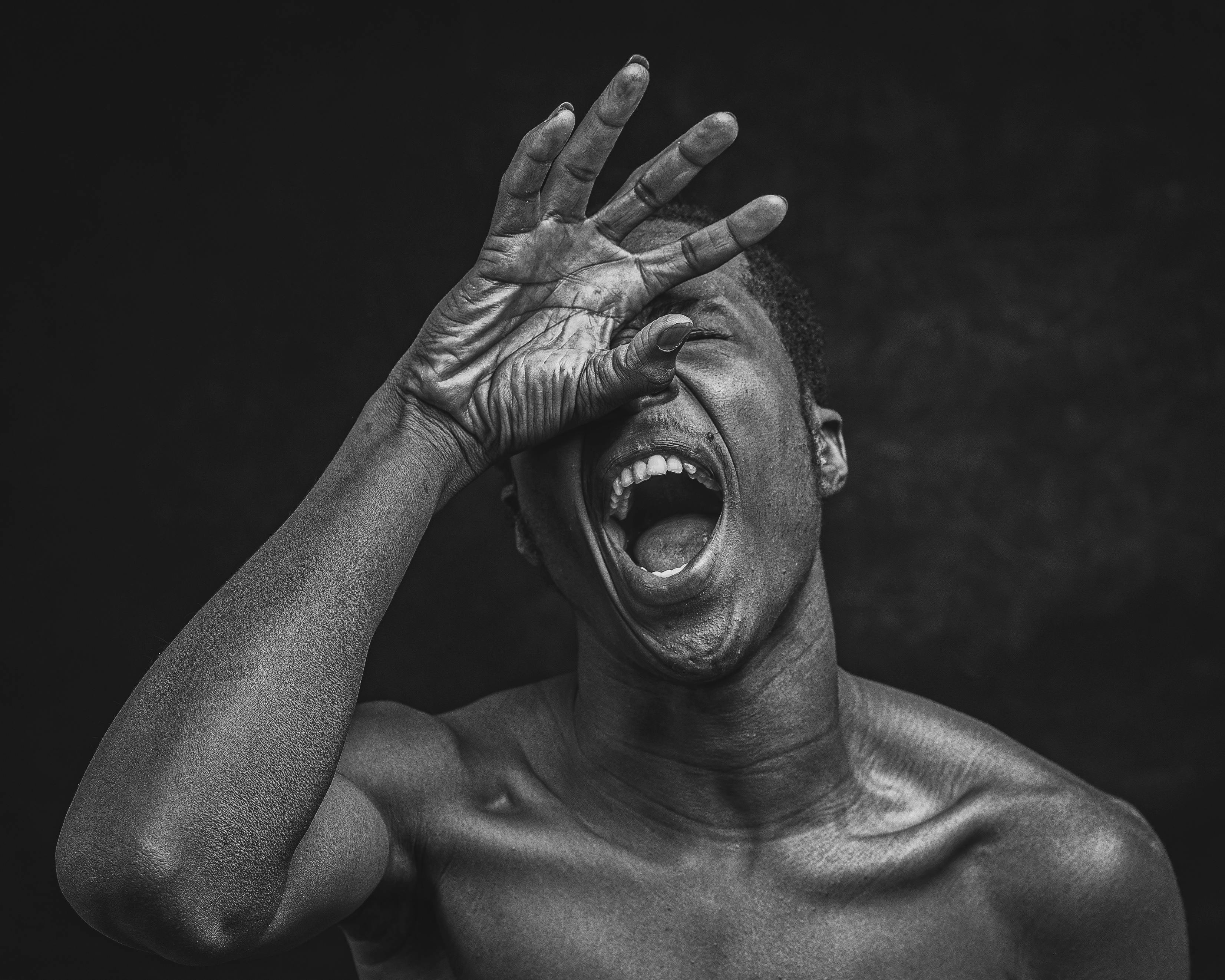 Gratis Ritratto drammatico in bianco e nero che cattura un'emozione intensa in una posa potente. Foto a disposizione