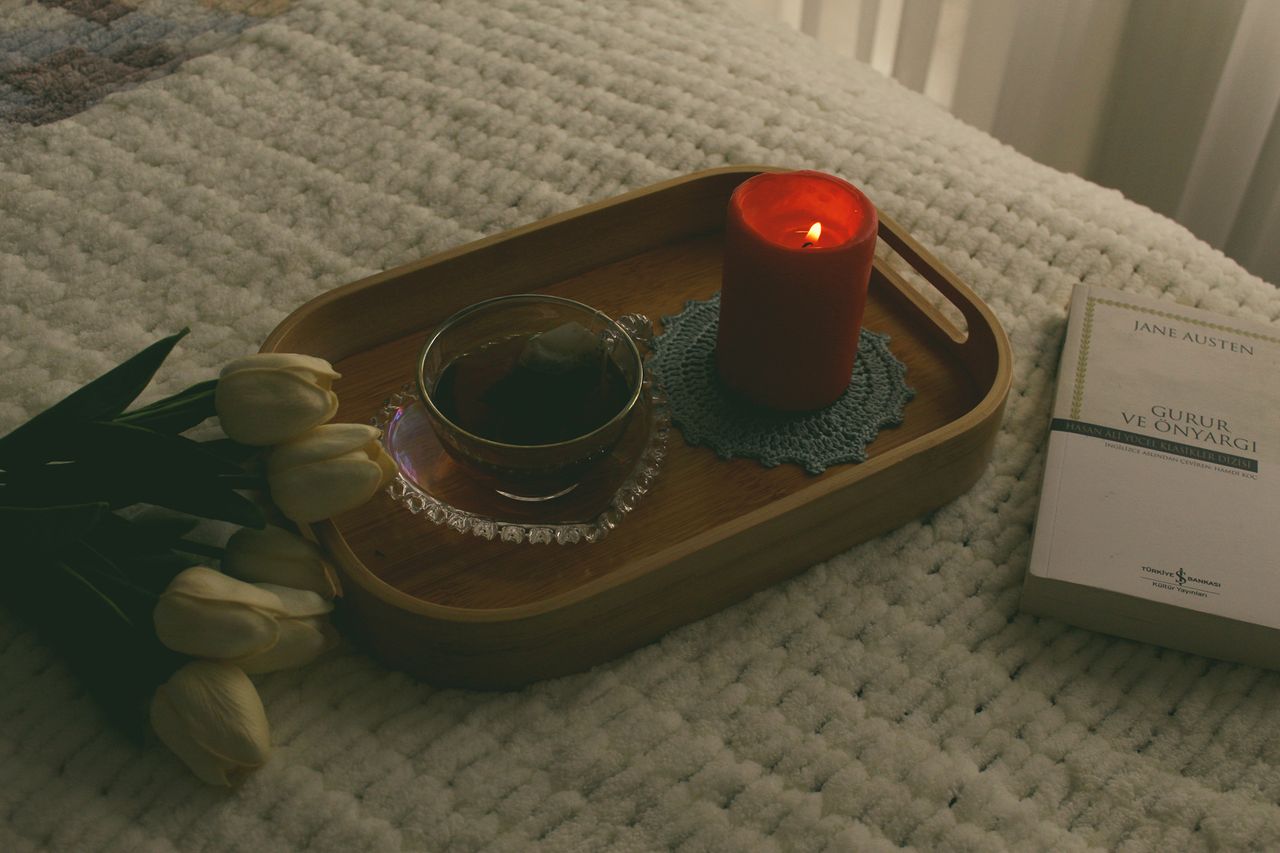 Bedside candle, tea, and book