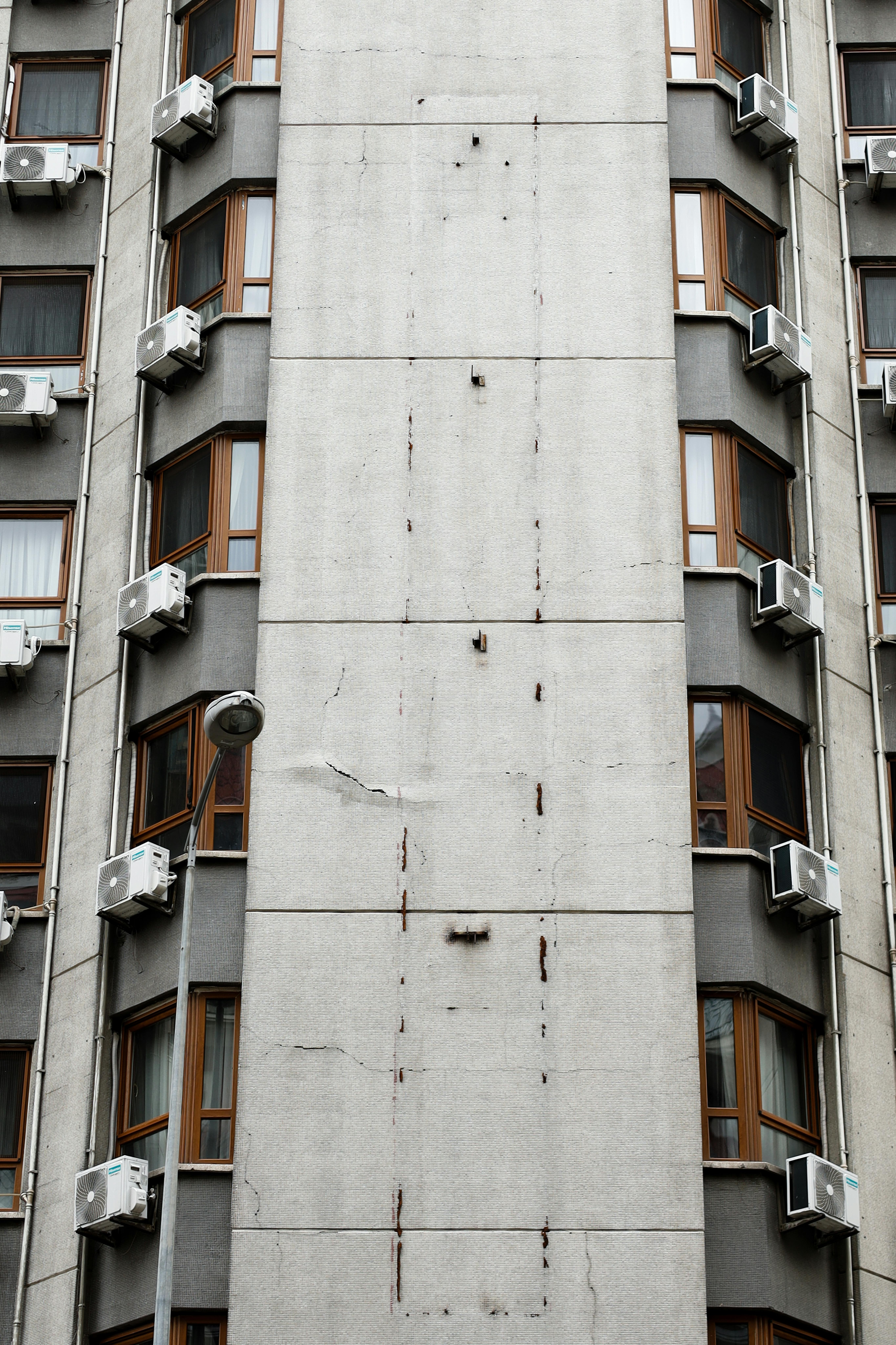 Kostenlos Nahaufnahme der Fassade eines Hochhauses mit mehreren Klimaanlagen in einem urbanen Umfeld. Stock-Foto