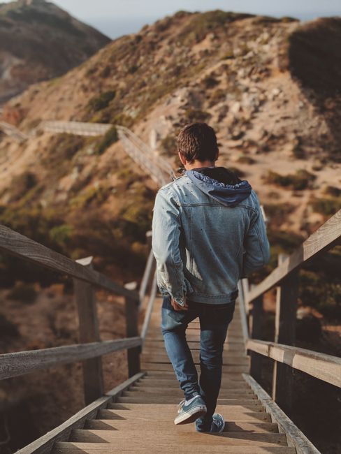 A man walks down wooden stairs at Cape Schanck, Australia, enjoying a scenic outdoor adventure. A man walks down wooden stairs at Cape Schanck, Australia, enjoying a scenic outdoor adventure.
