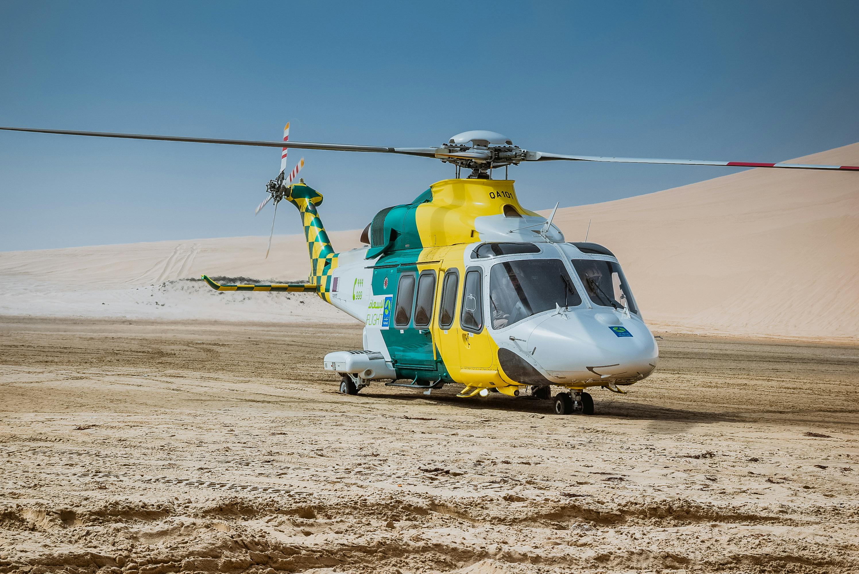 Δωρεάν Ένα κίτρινο και πράσινο ιατρικό ελικόπτερο σταθμευμένο στην έρημο κοντά στη Ντόχα, στο Κατάρ κάτω από έναν καθαρό μπλε ουρανό. Φωτογραφία από στοκ φωτογραφιών