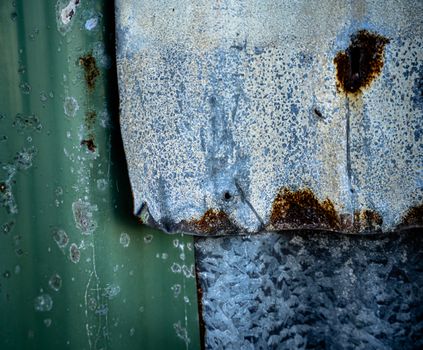 Detailed texture of rusty and weathered corrugated metal, showcasing patina and decay.