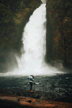 一个人站在风景秀丽的大瀑布底部