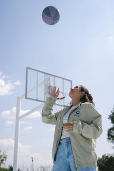 Woman enjoying a sunny day playing basketball outdoors in León, Mexico.