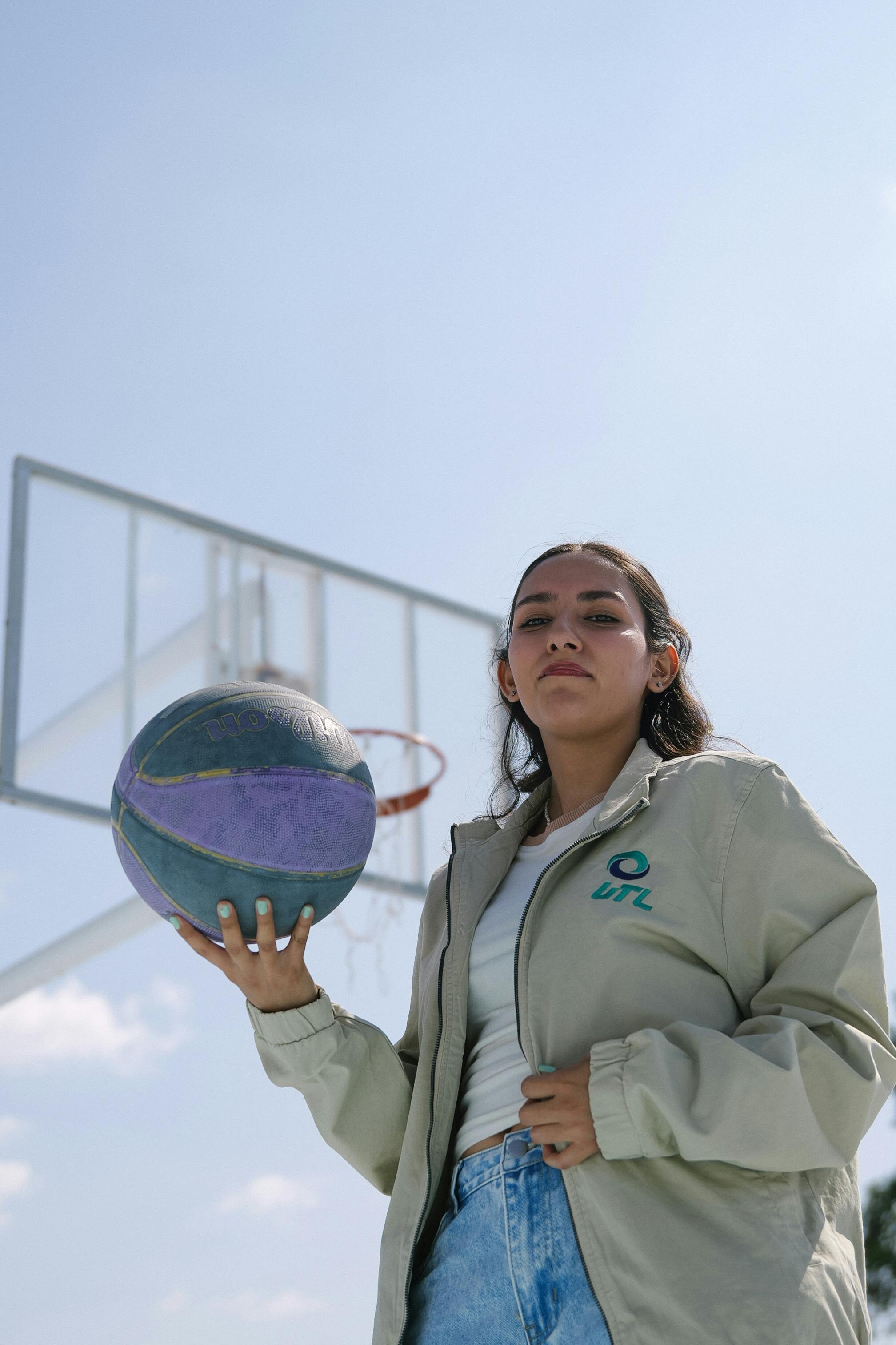 bezplatná Sebevědomá mladá žena s basketbalovým míčem na hřišti v Leónu, Guanajuato, Mexiko. Základová fotografie