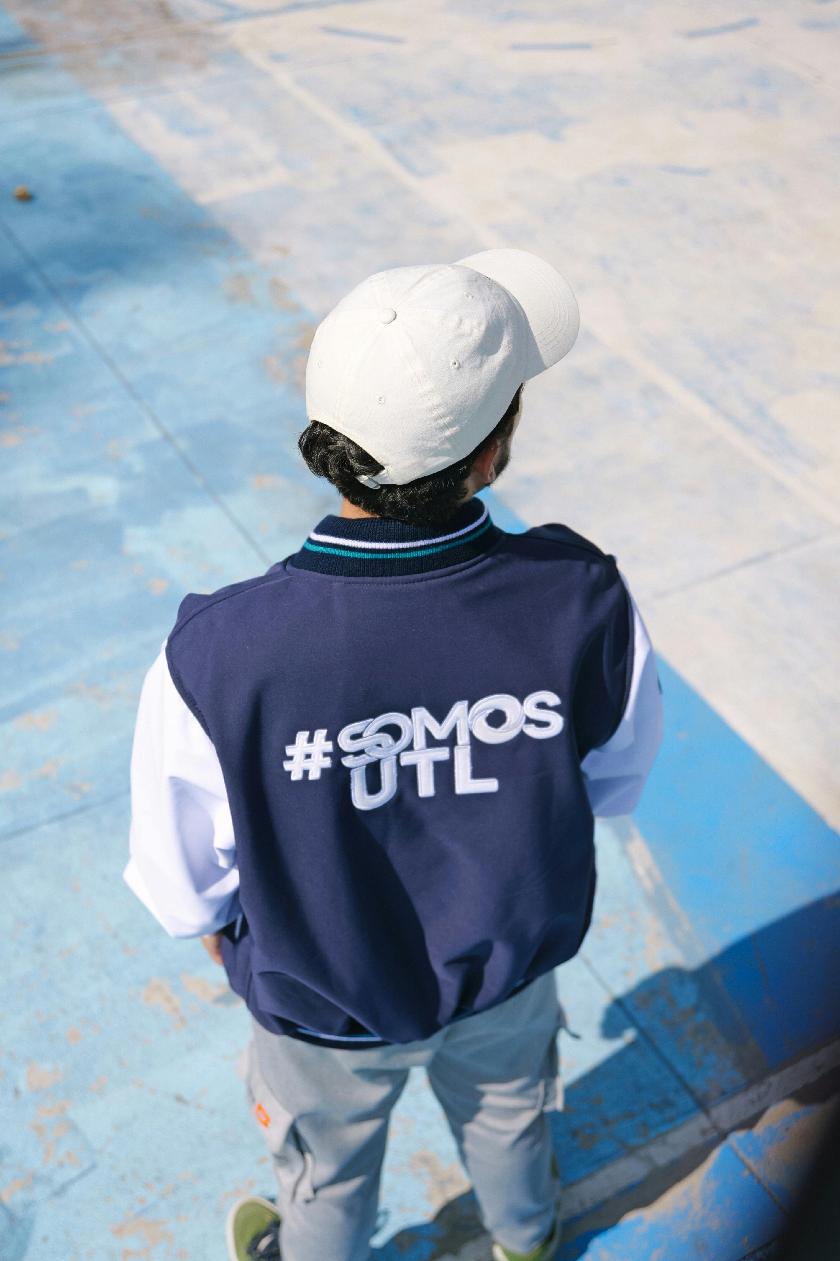 Free A student in a #SomosUTL jacket stands outdoors on a sunny day. Stock Photo