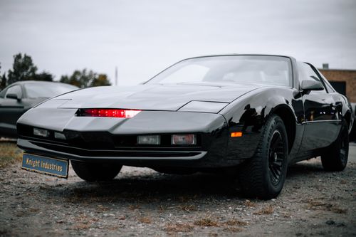 Free A sleek black sports car with a 'Knight Industries' plate, evoking retro futuristic vibes. Stock Photo