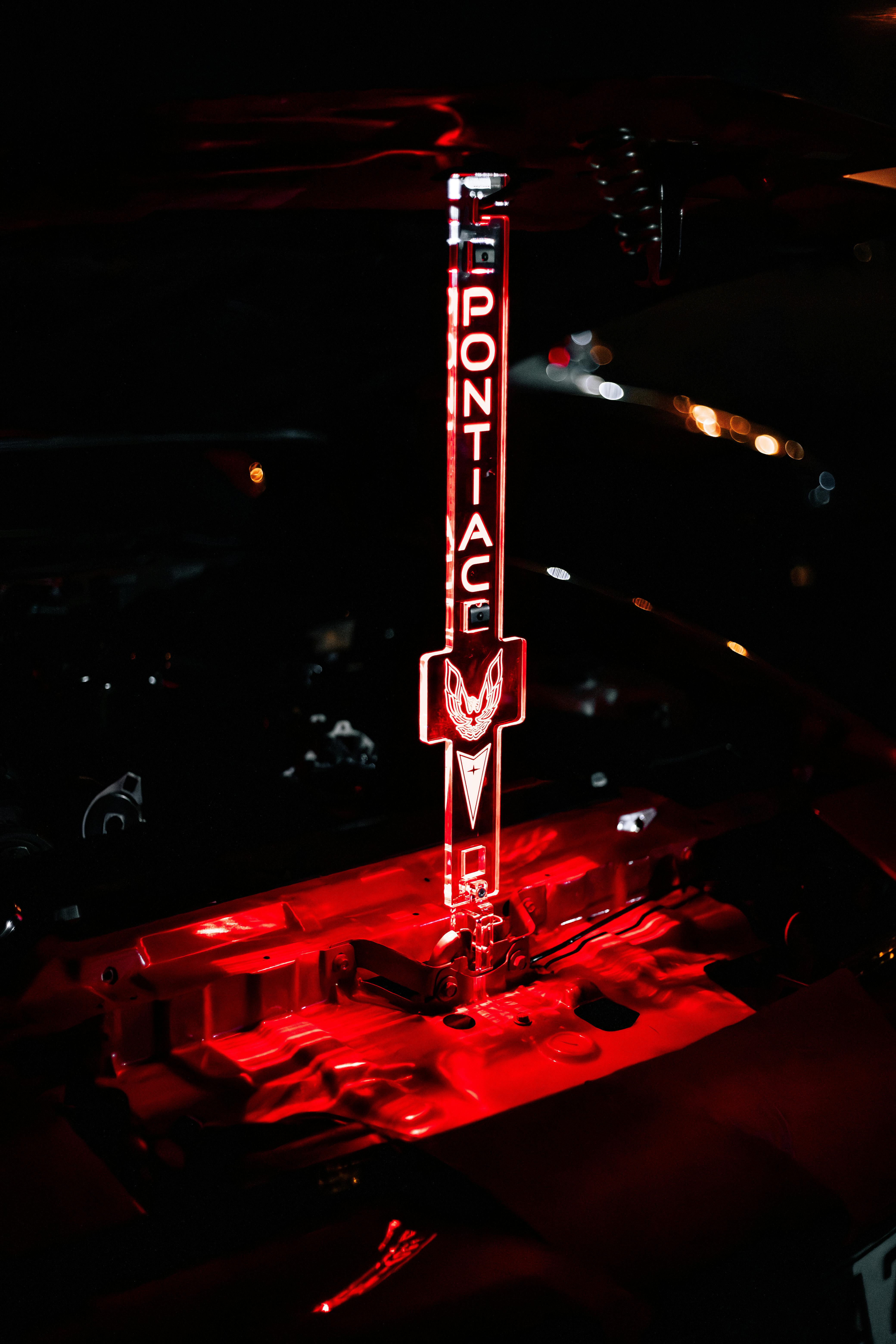 Δωρεάν Κοντινό πλάνο ενός λαμπερού λογότυπου Pontiac σε χώρο κινητήρα με εντυπωσιακό κόκκινο φωτισμό. Φωτογραφία από στοκ φωτογραφιών