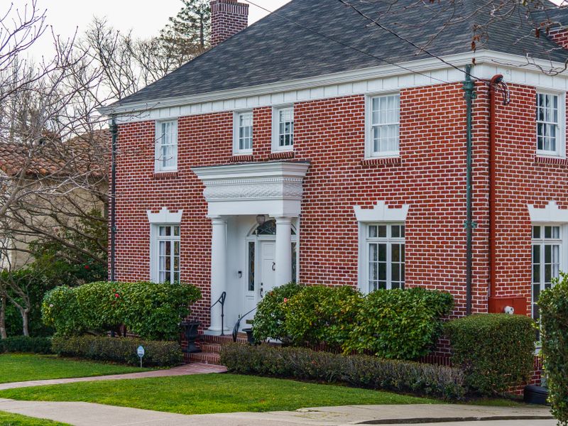 Traditional red brick home with a lush front garden