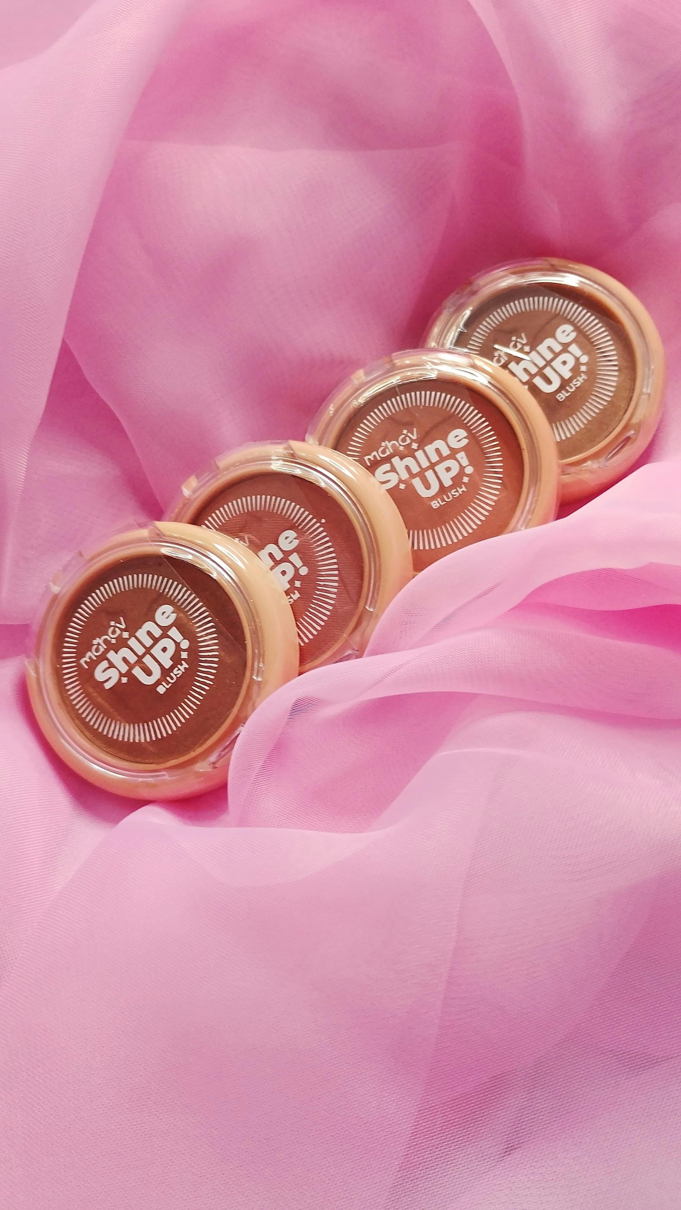 ingyenes Négy kozmetikai kiemelő puha rózsaszín anyagra helyezve, elegáns szépségmegjelenítést teremtve. Stockfotó