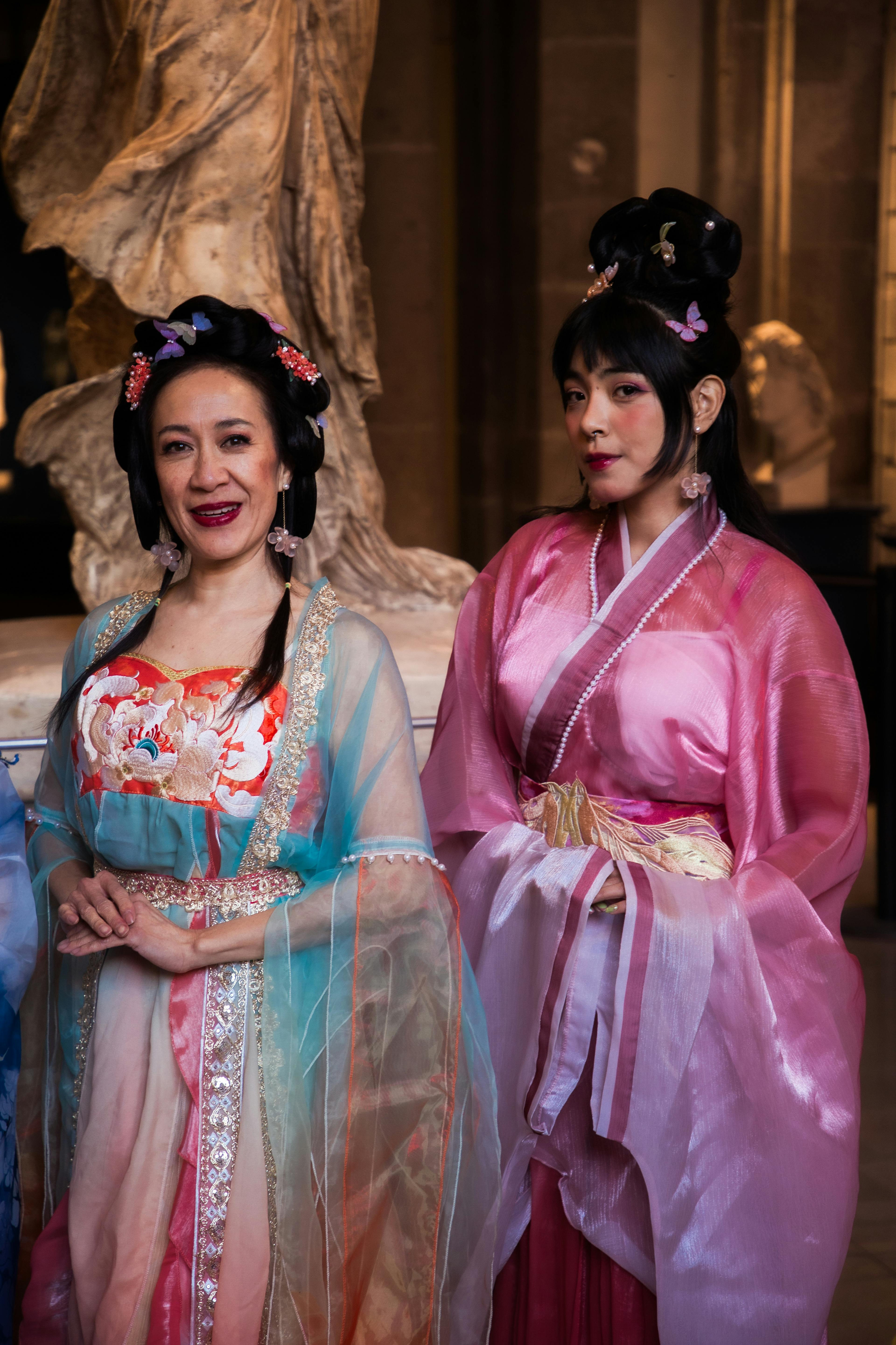 Gratuit Des femmes en tenues traditionnelles colorées dans un musée de sculptures. Photos