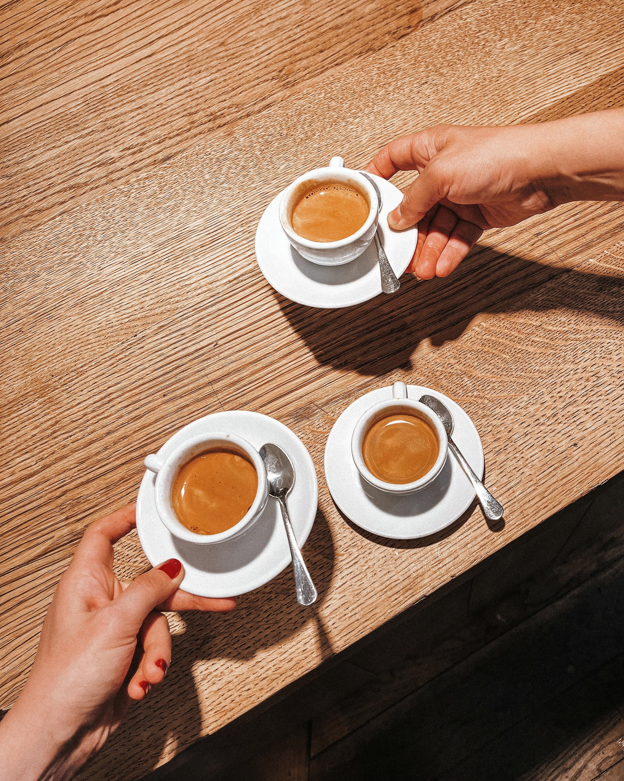 Miễn phí Ba người đang cùng nhau thưởng thức cà phê espresso tại một chiếc bàn gỗ ở London, Anh. Ảnh lưu trữ